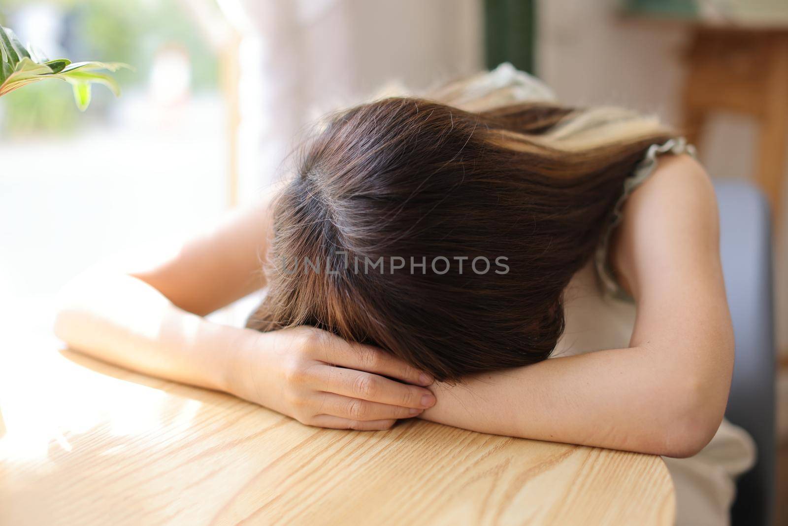 Young Asian woman resting with sleeping in a coffee shop by piyato