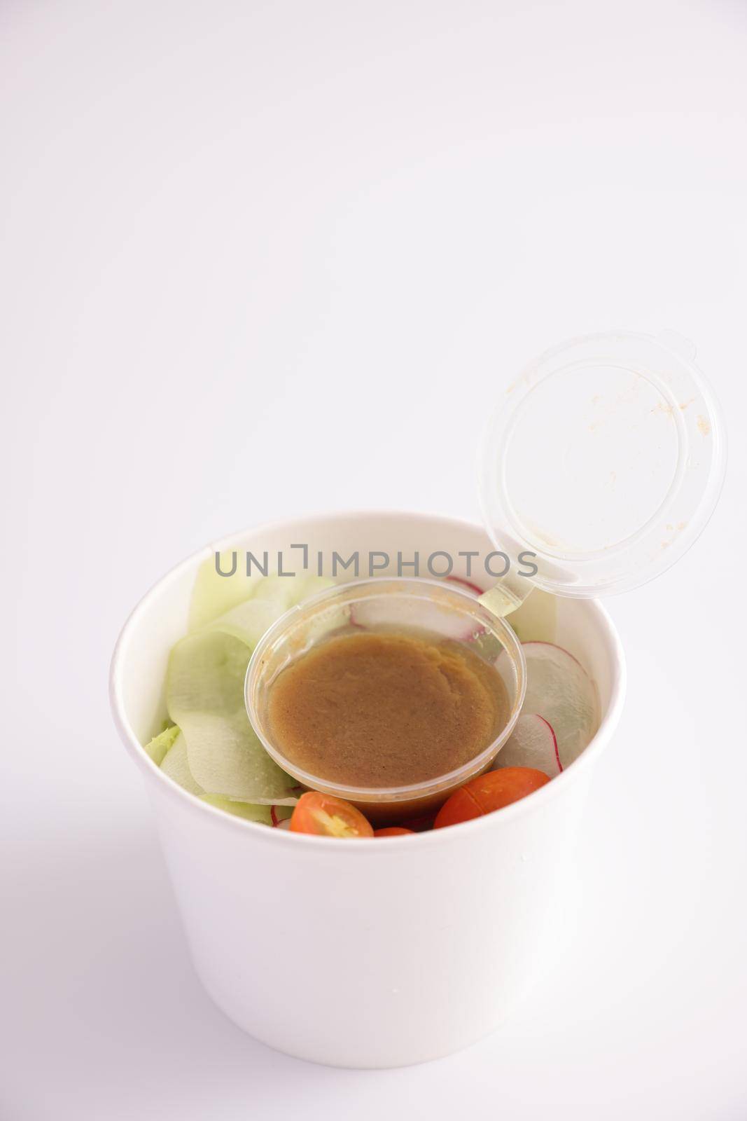 Salad in plastic package for take away or food delivery isolated on white background by piyato