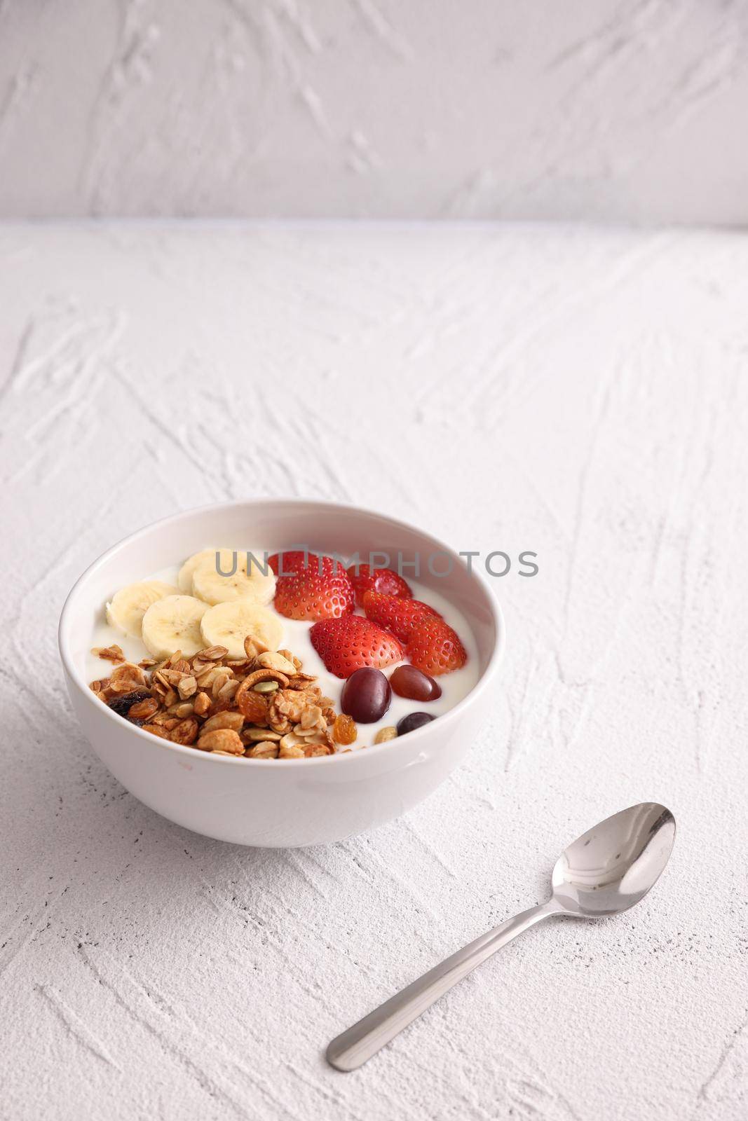 bowl of granola cereal with yogurt and berries isolated on white background by piyato