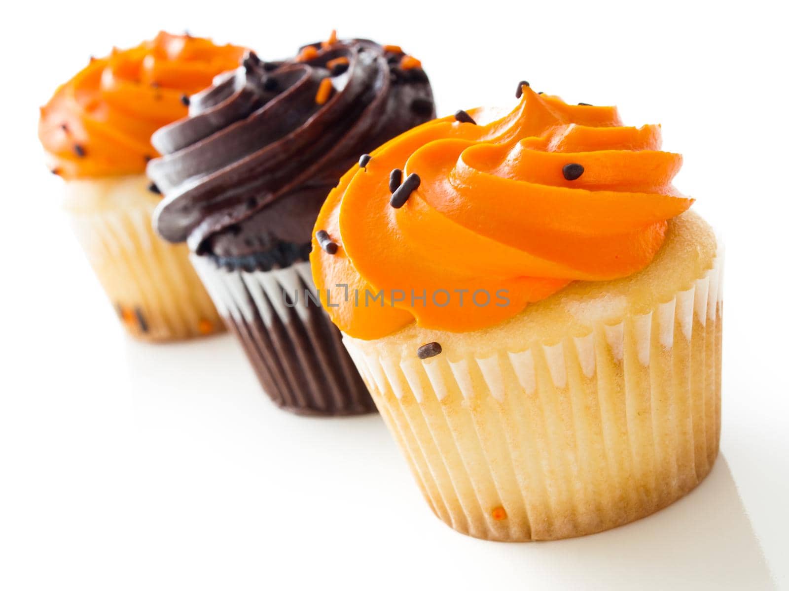 Halloween orange and black cupcakes on white background.