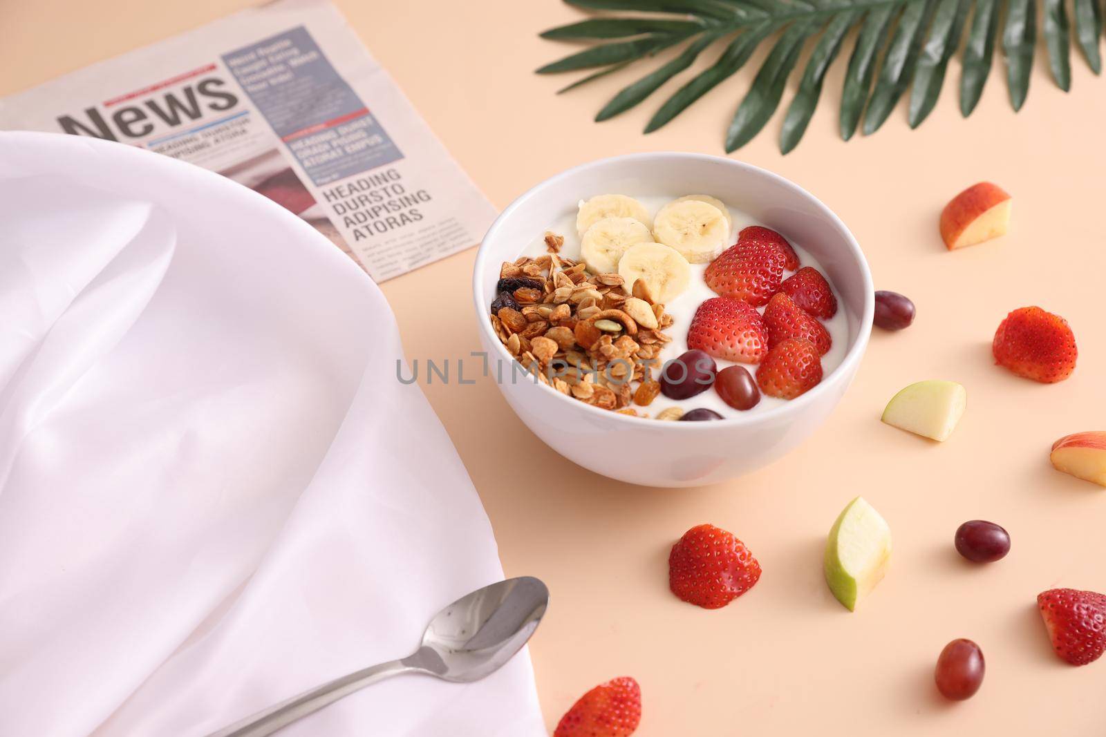 bowl of granola cereal with yogurt and berries isolated on eggnog color background by piyato