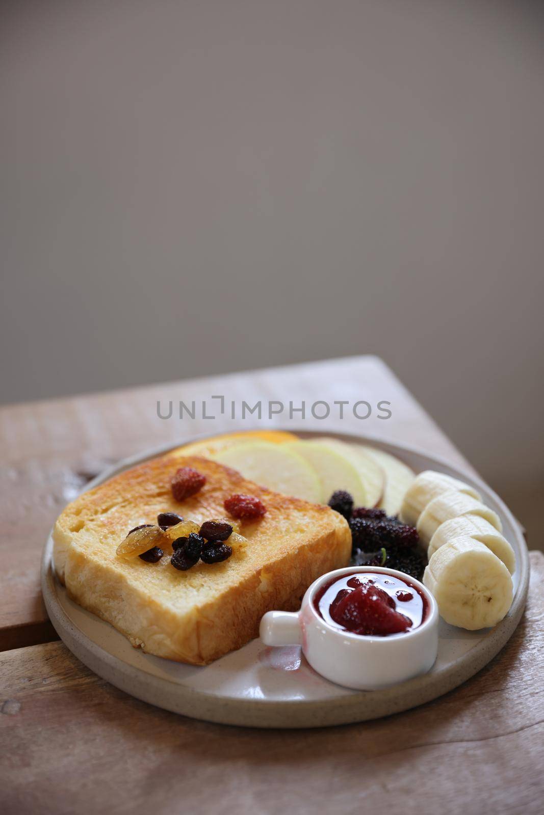 Toast breakfast with dried berry and jam on wood background