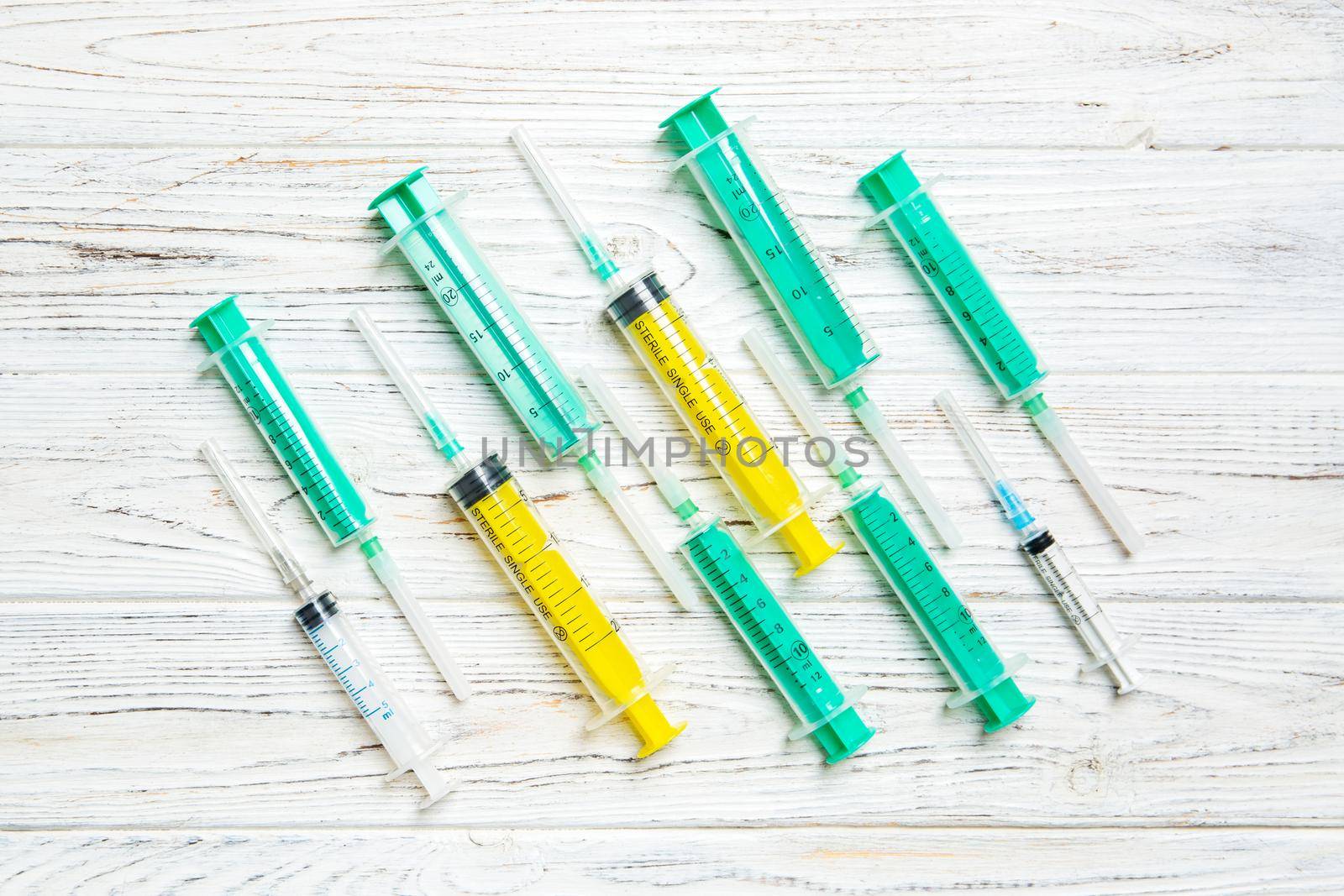 Top view of many syringes prepared for injection at wooden background. Treatment concept with copy space.