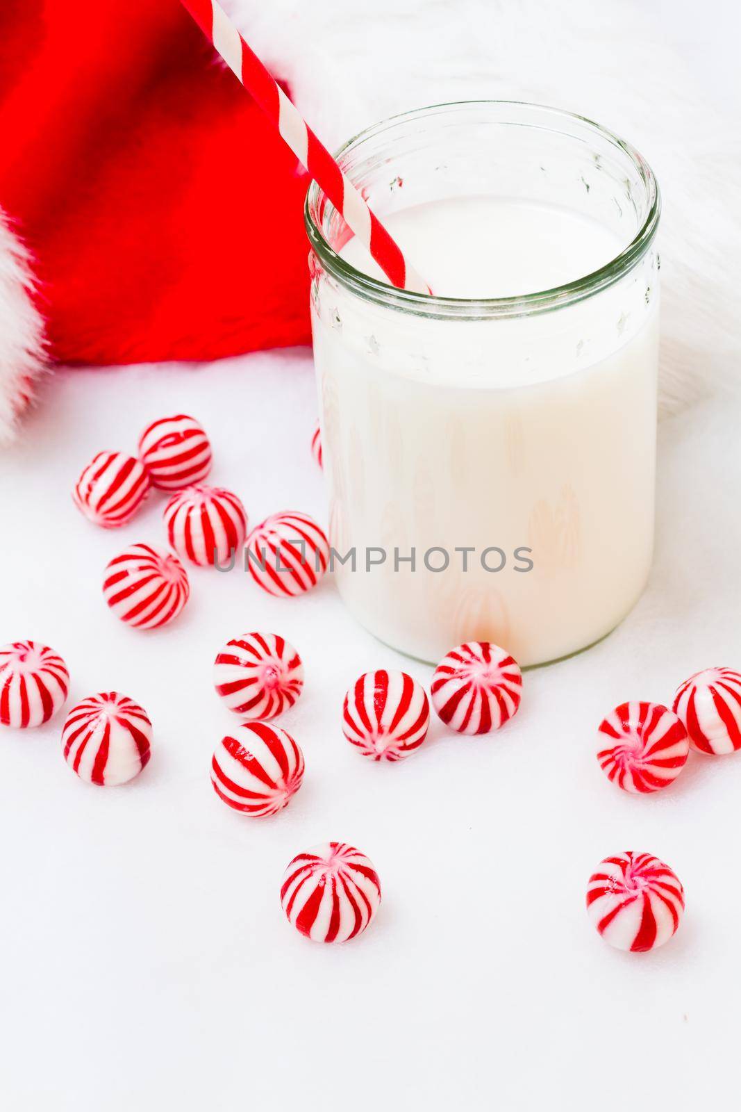 Glass of milk in a jar with a red straw.