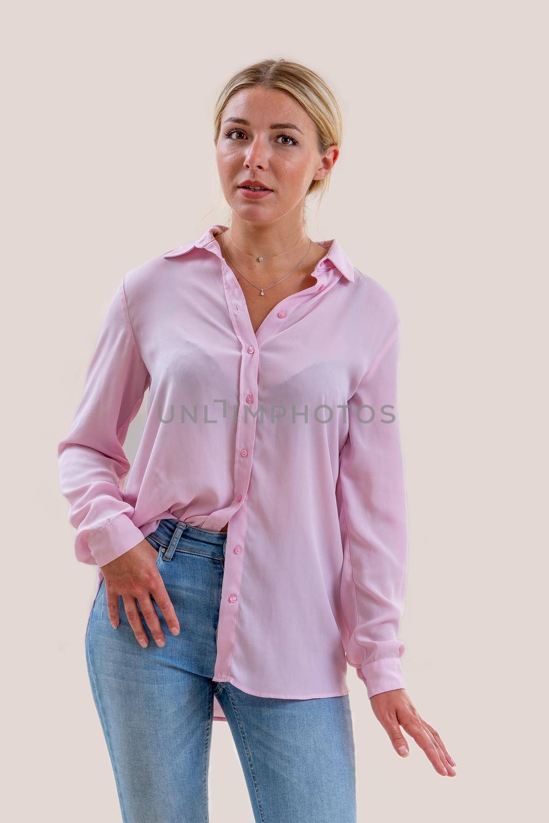 Young woman standing casually dressed on a cropped white background.