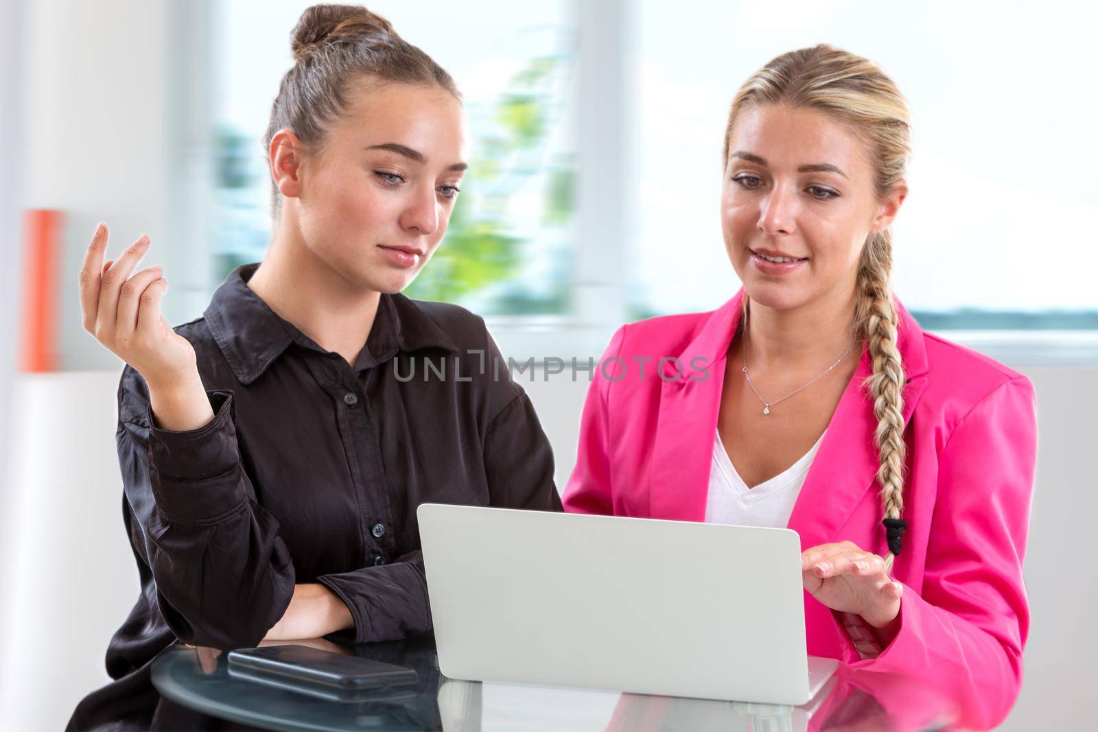 Two young women in front of a computer by JPC-PROD