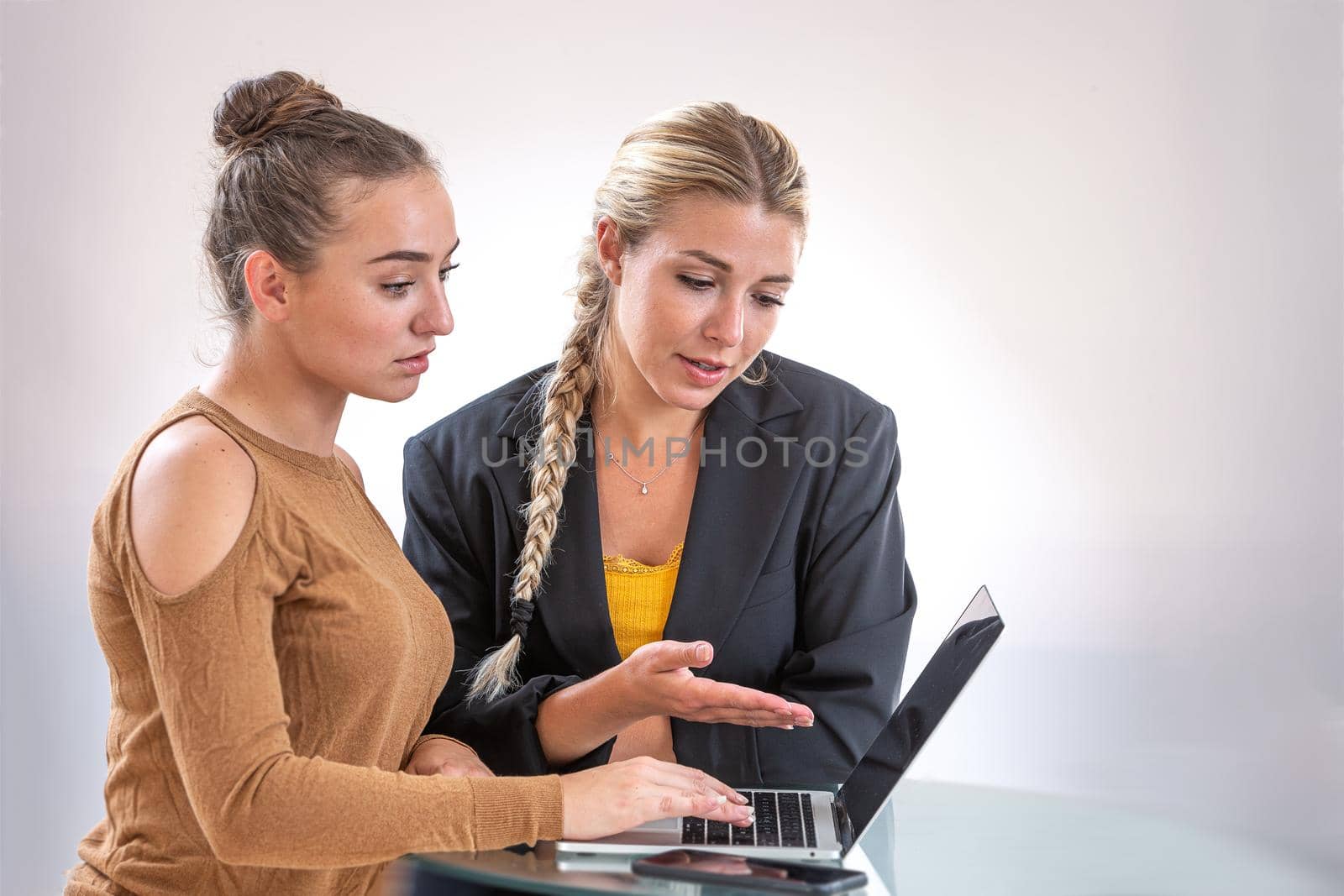 Two young women in front of a computer by JPC-PROD