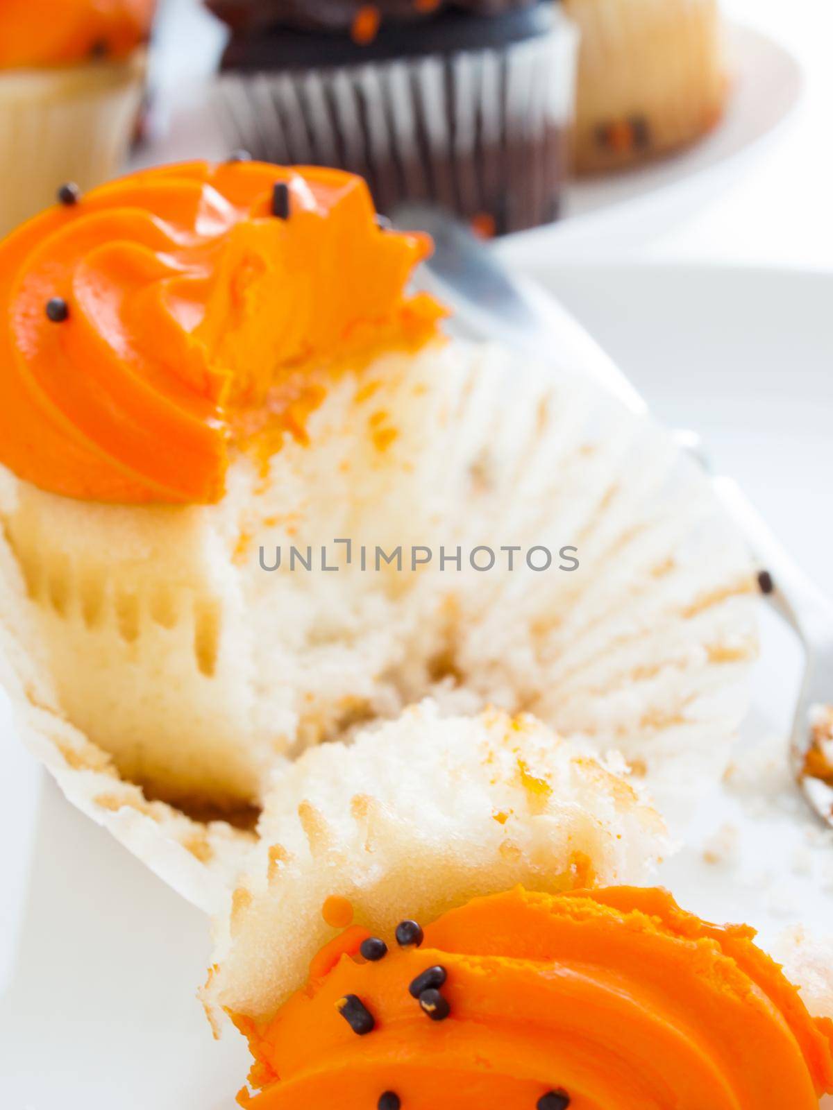 Eating Halloween cupcakes with orange and black icing.