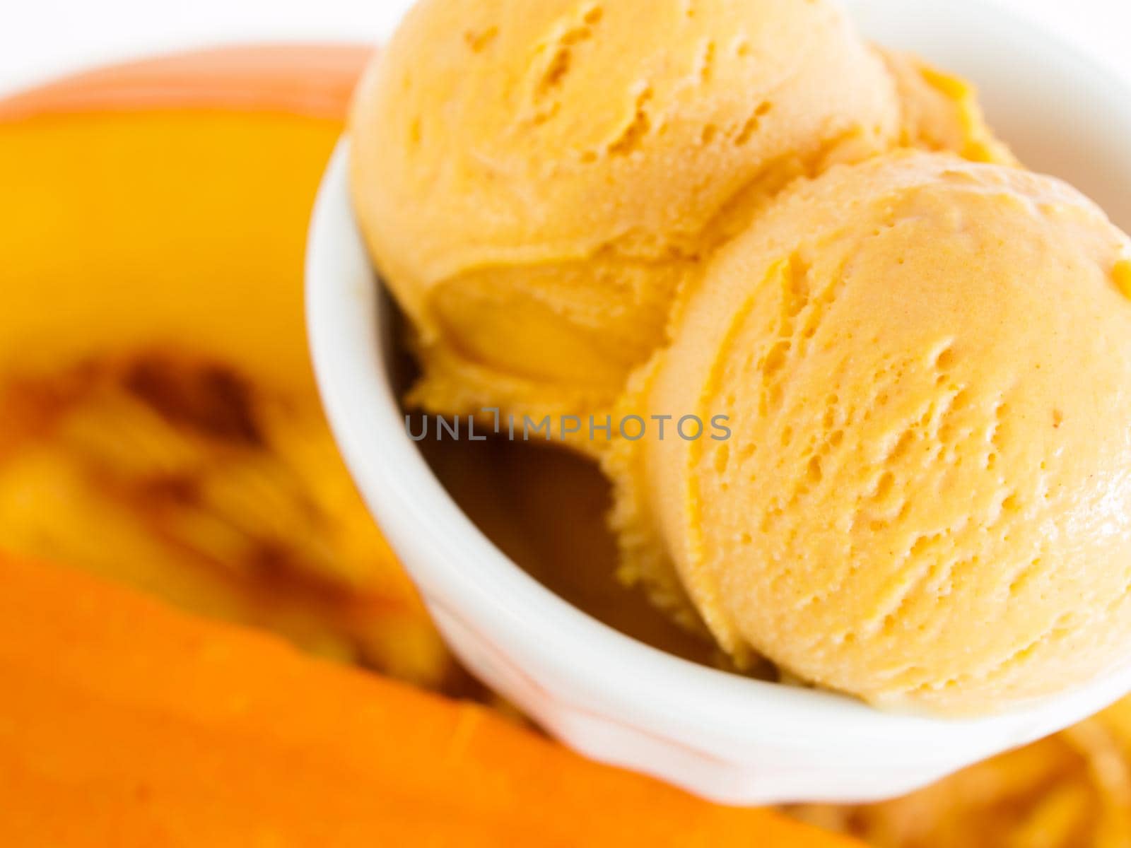 Scoop of gourmet pumpkin gelato in white bowl.