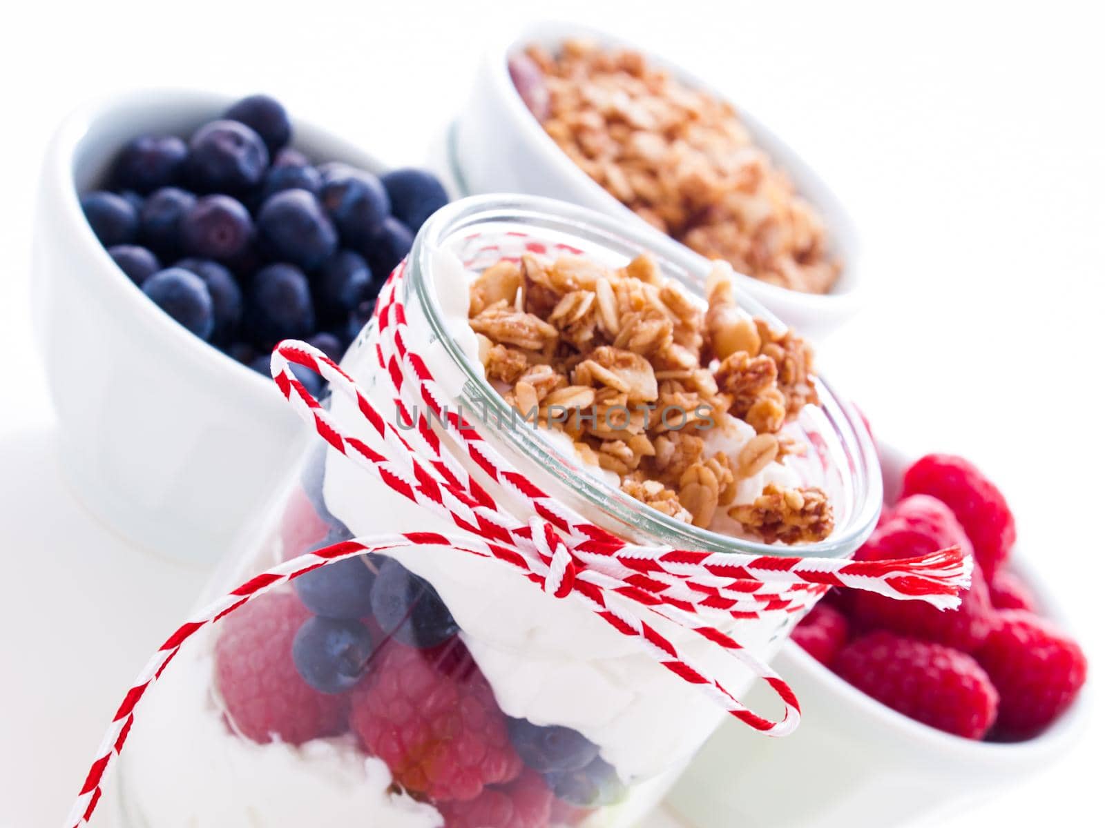 Delicious fruit, greek yogurt and granola parfaits on white background