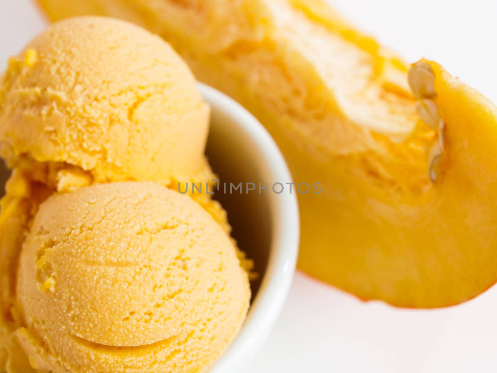 Scoop of gourmet pumpkin gelato in white bowl.
