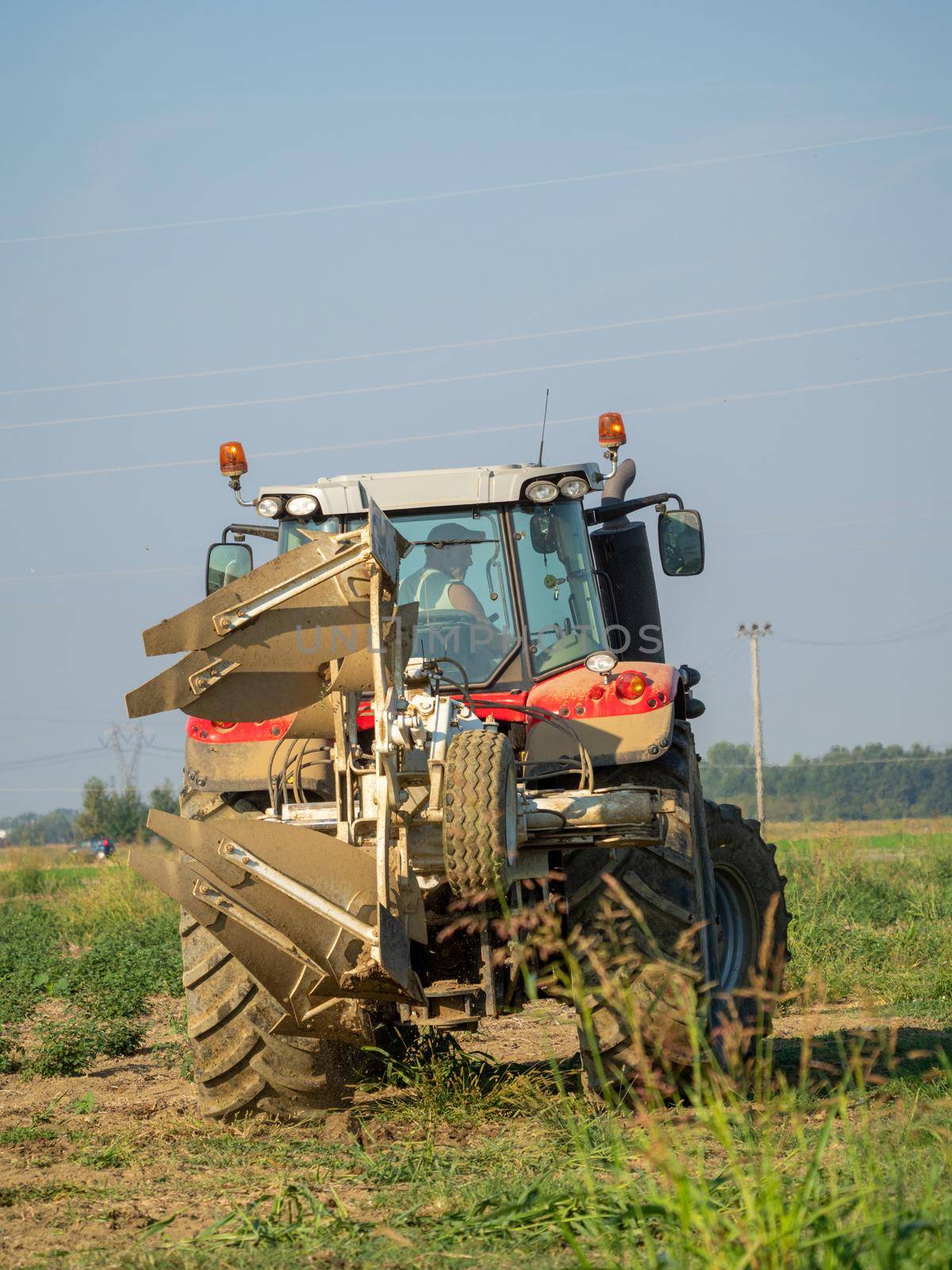 farmer with tractor plowing the land in the countryside.
