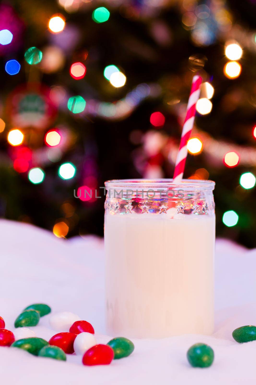 Glass of milk in a jar with a red straw.