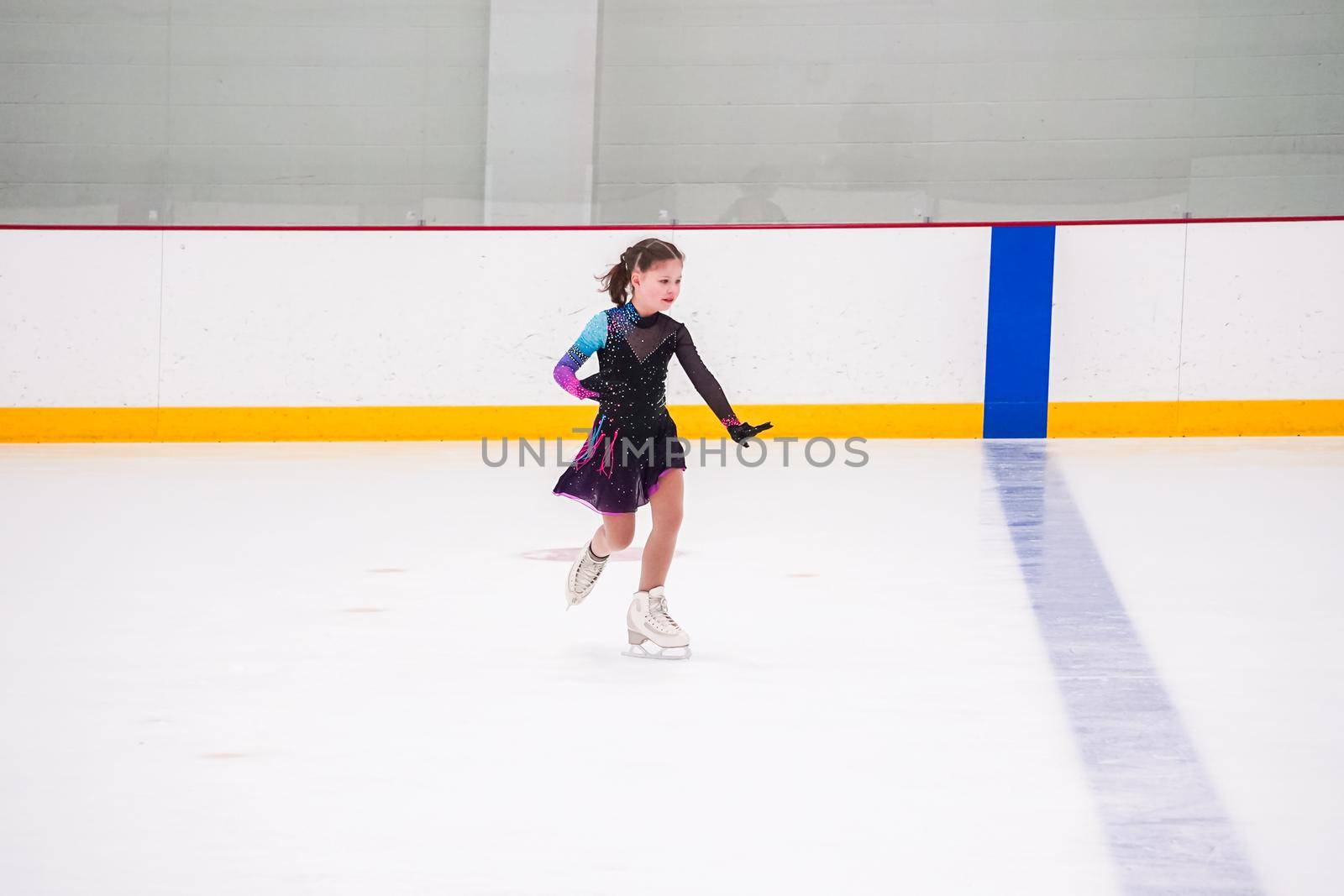 Little girl practicing before her figure skating competition at the indoor ice rink.