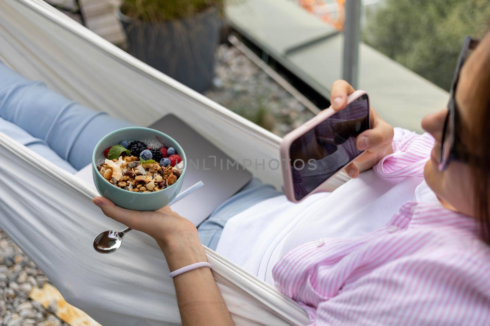 woman with laptop in hammock eating chia pudding. High quality photo