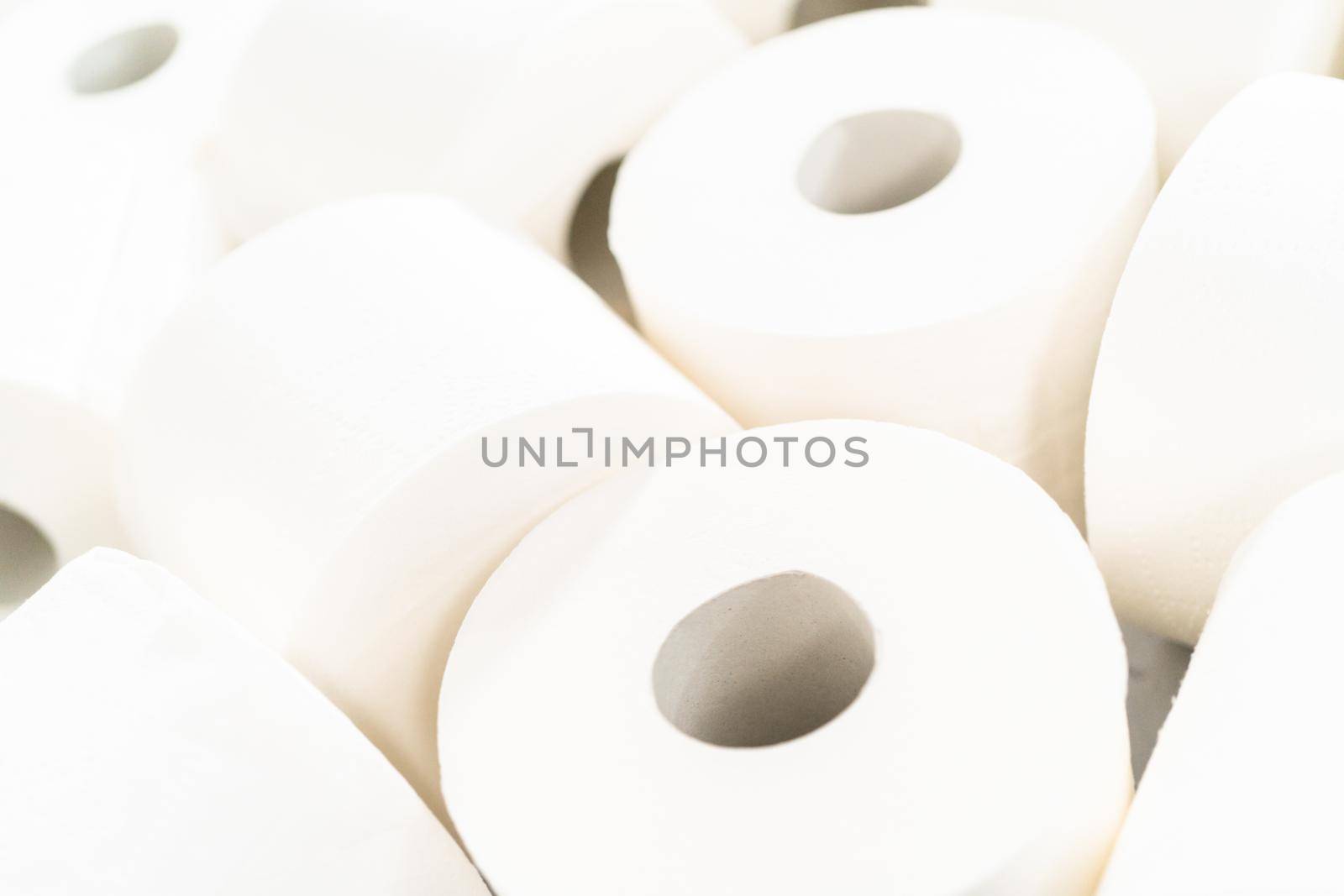 New white toilet paper rolls on a gray background.