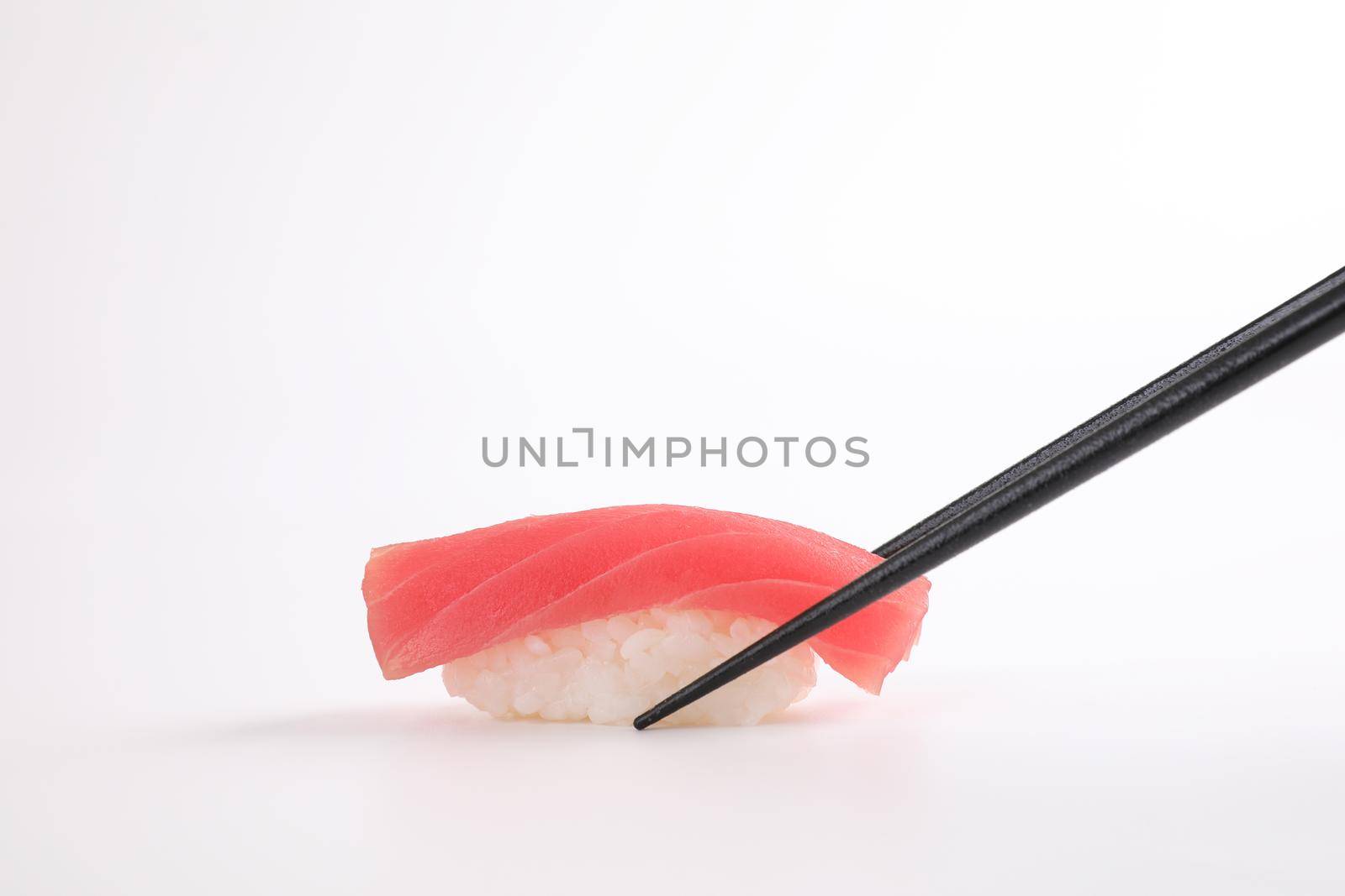 Tuna sushi with chopsticks , Japanese food isolated in white background by piyato
