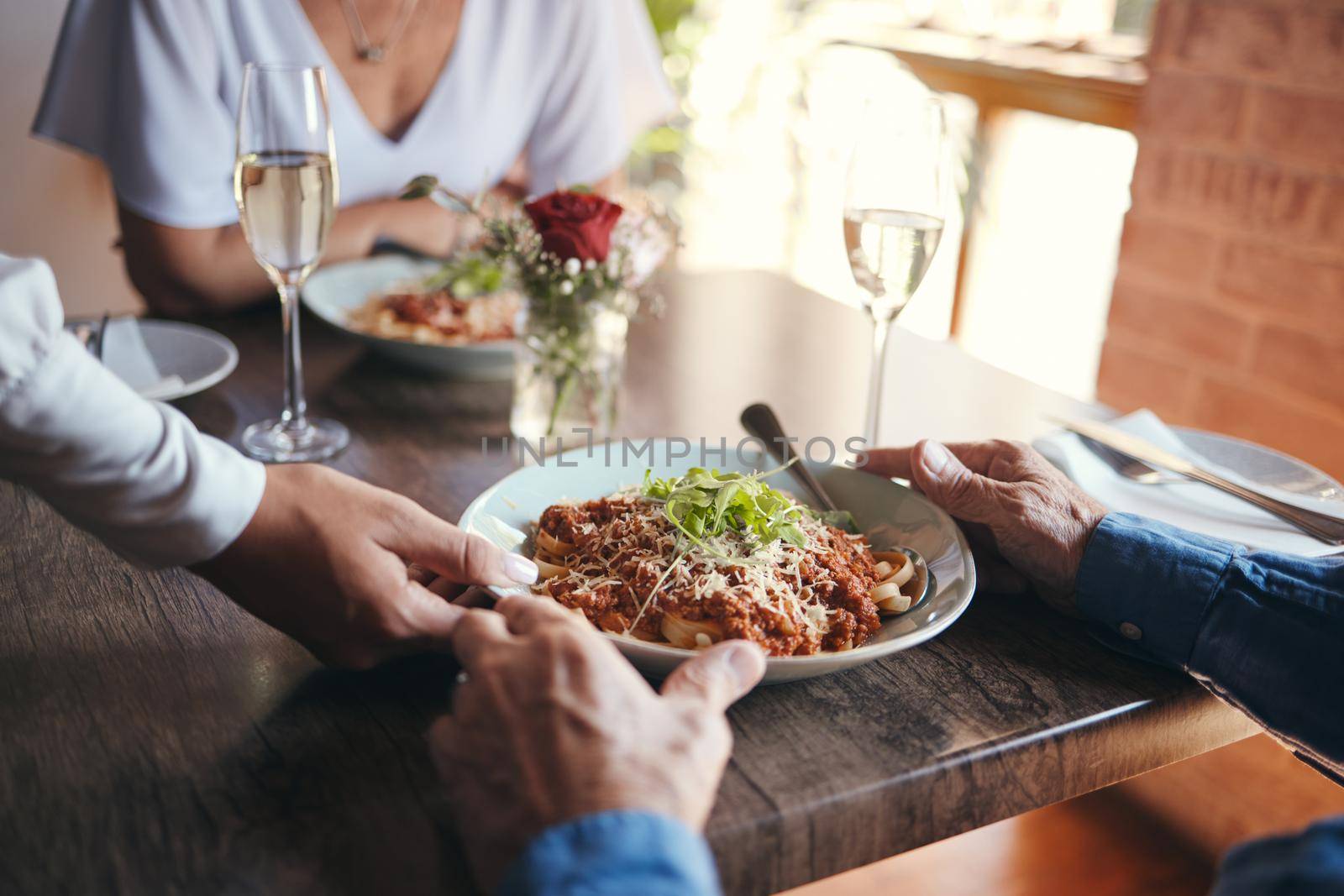 Food service, wine and couple at table with hospitality from waiter at restaurant for lunch. Cafe worker with plate of pasta for man and woman on date for anniversary or marriage at fine dining cafe.