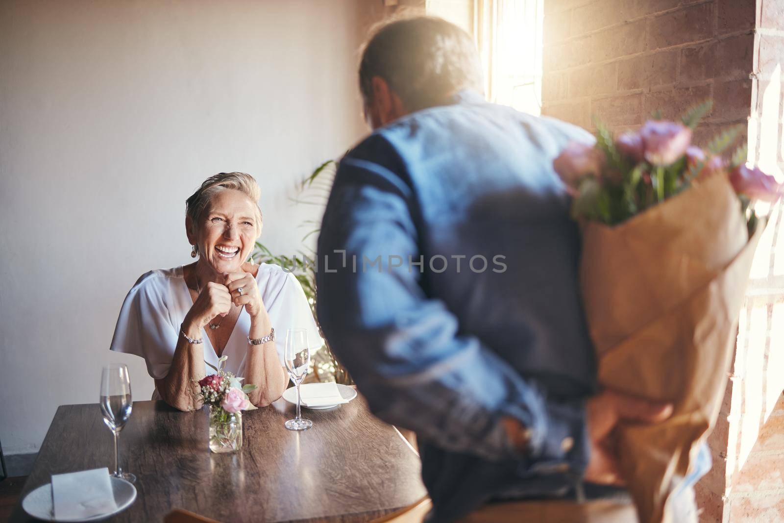 Elderly, couple and flowers on a date for surprise, love and romance in their house. Senior woman, man and retirement together with bouquet to celebrate marriage, birthday or anniversary in the home by YuriArcurs