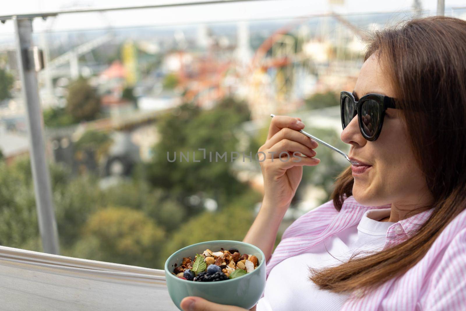 young woman eating chia pudding with nuts and berries. High quality photo