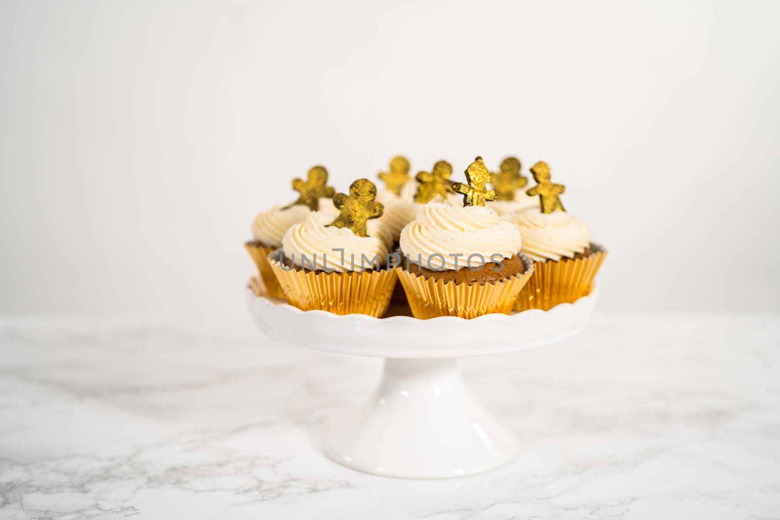 Freshly baked gingerbread cupcakes with eggnog buttercream frosting and topped with a gingerbread man.