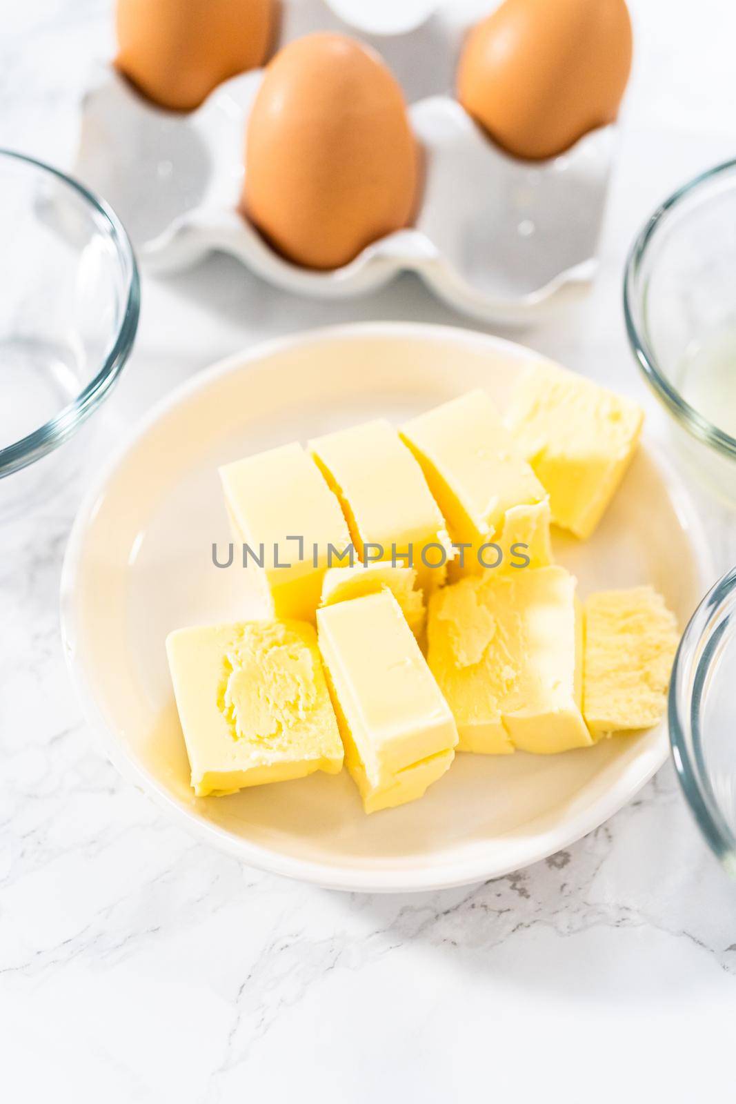 Measured ingredients in glass mixing bowls to prepare hollandaise sauce.