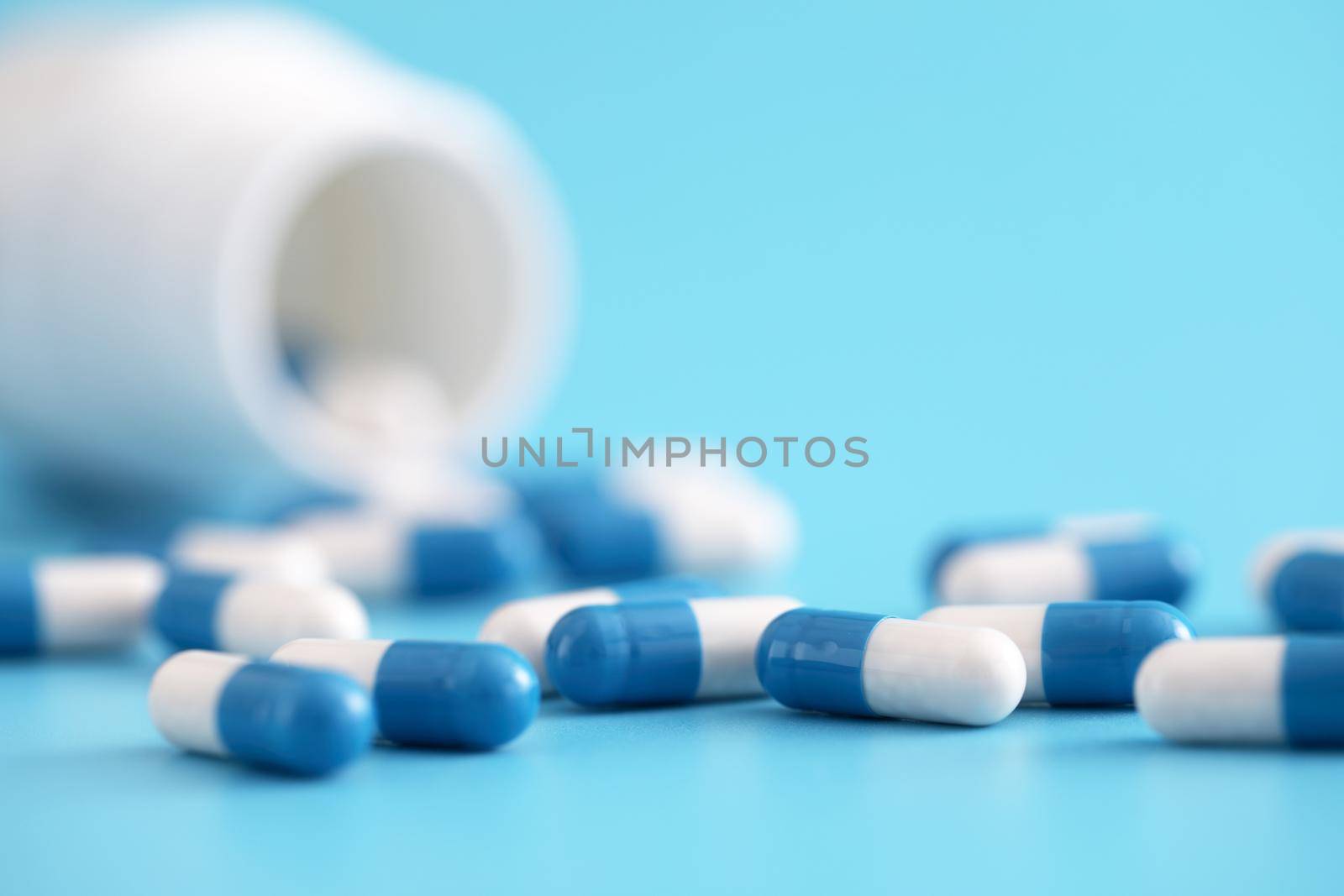 pills capsules with bottle isolated on blue background by piyato