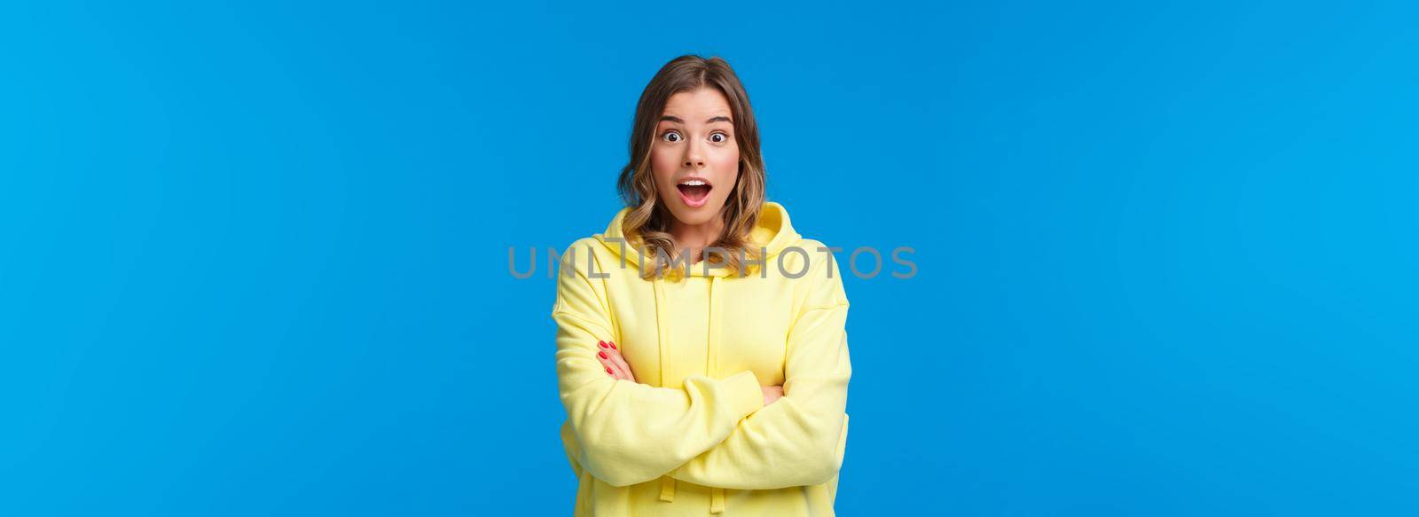 Really omg. Impressed and surprised blond woman react astonished listening stunning shocking story, open mouth and look camera with amazement, cross hands chest casual pose over blue background by Benzoix