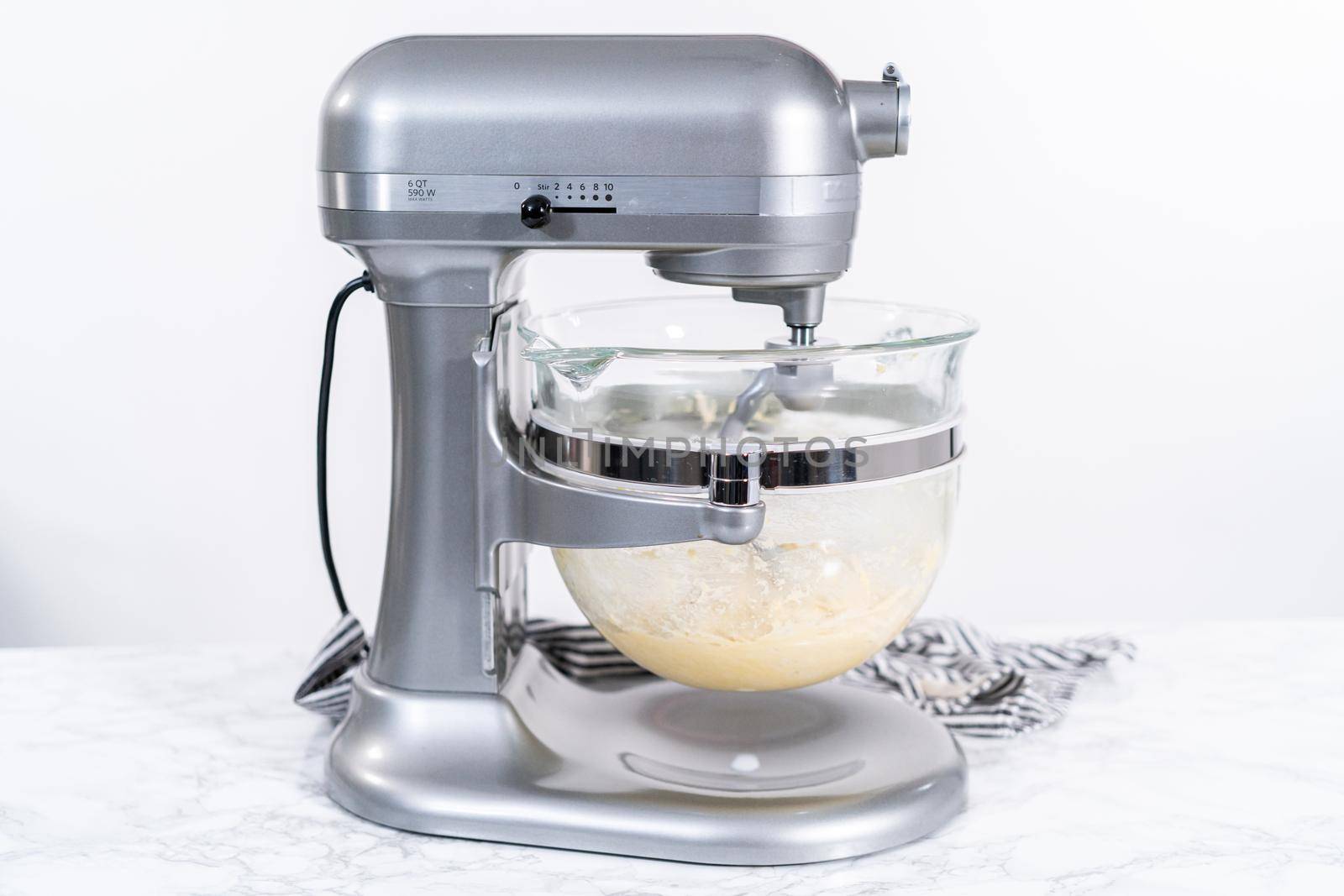 Mixing ingredients in kitchen mixer to bake homemade brioche buns.