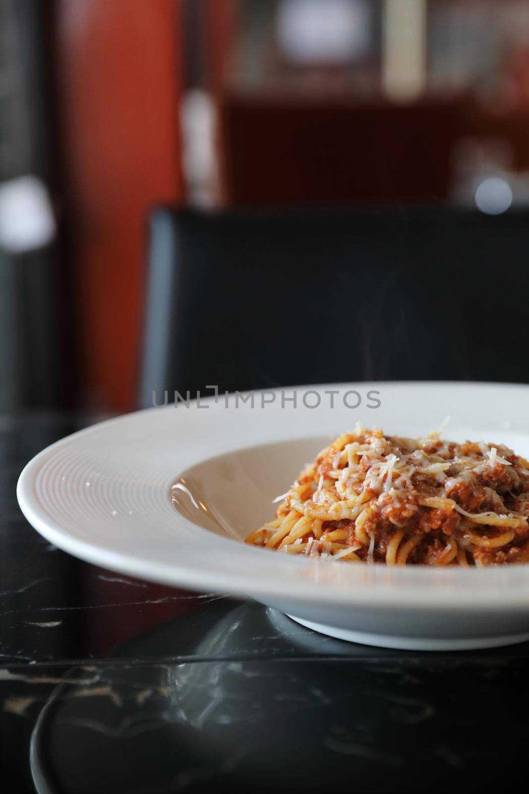 spaghetti Bolognese with minced beef and tomato sauce garnished with parmesan cheese and basil , Italian food by piyato