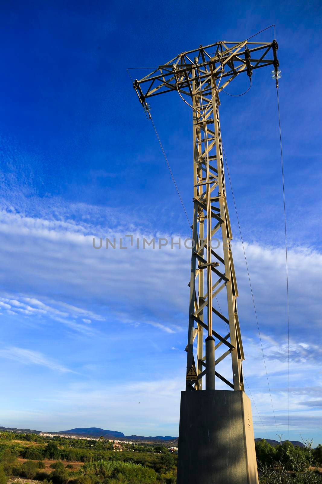 Power lines tower under blue sky in the countryside by soniabonet