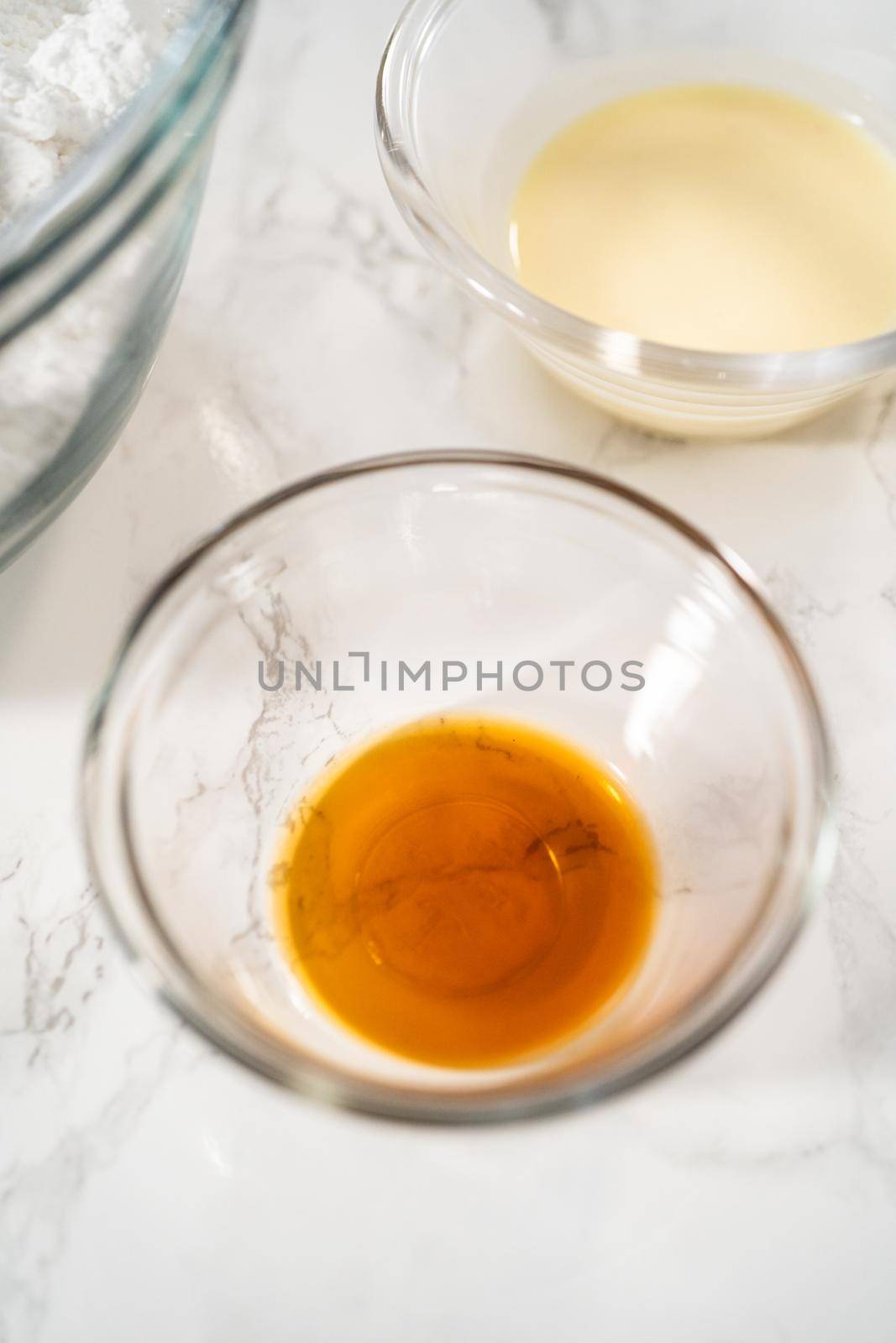 Measured ingredients in glass mixing bowls to make eggnog buttercream frosting.