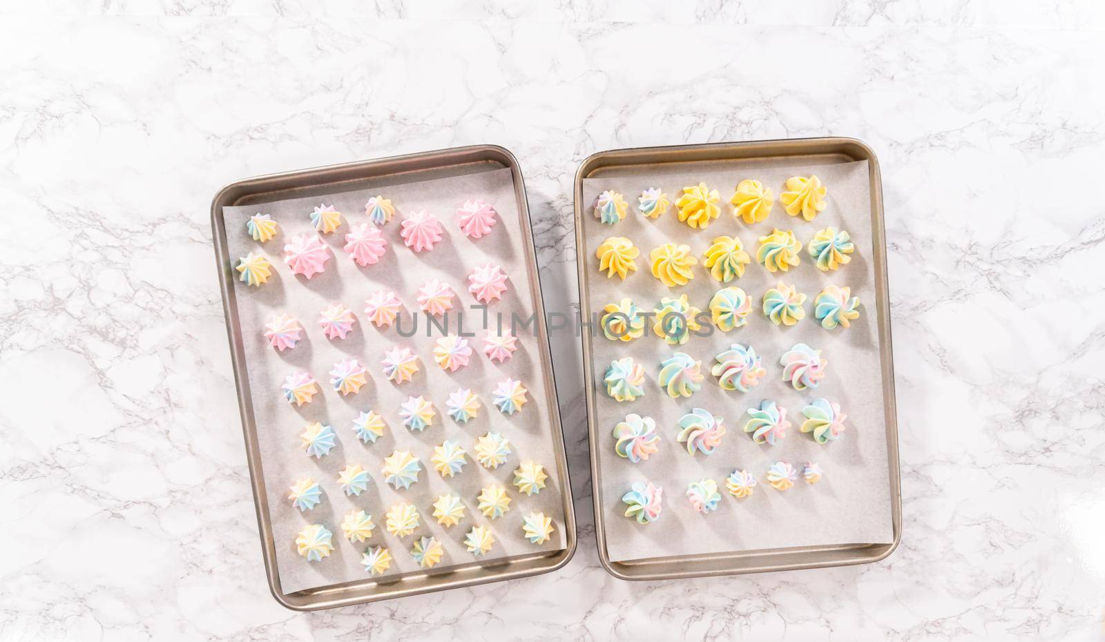 Flat lay. Unbaked unicorn meringue cookies on a baking sheet with a parchment paper.