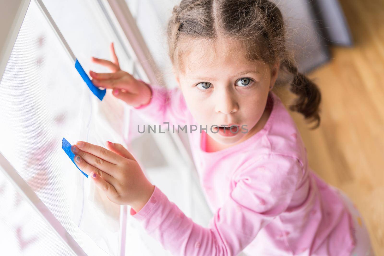 Little girl planting seeds for indoor vegetable garden.