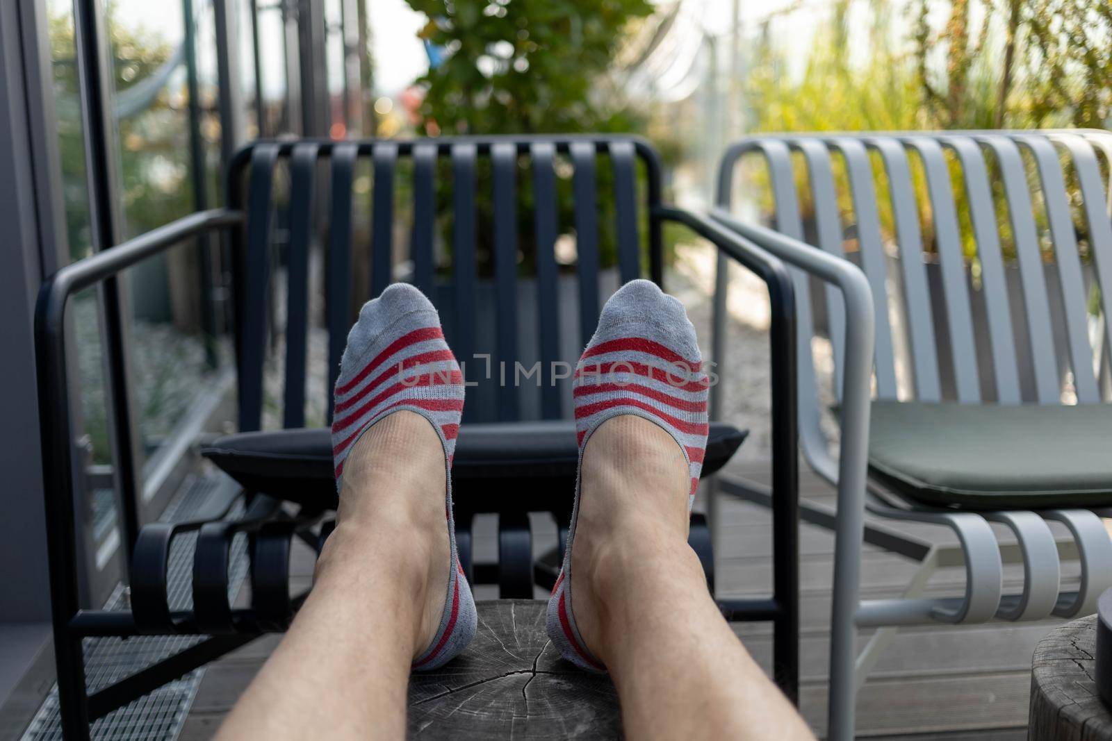 male legs in short socks stretched on the terrace. High quality photo