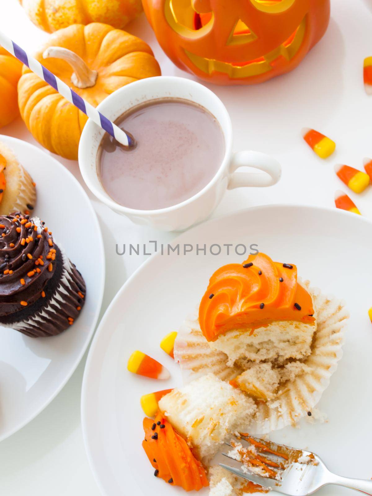 Eating Halloween cupcakes with orange and black icing.