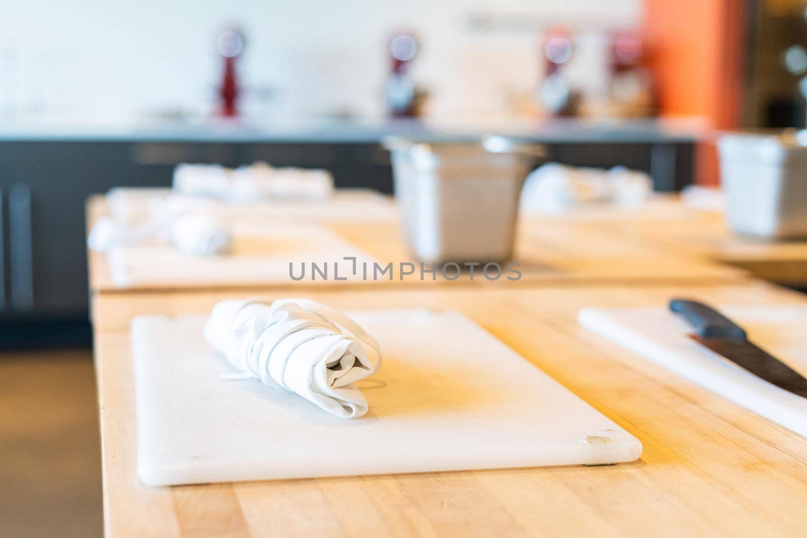 Tables prepared with white cutting boards and aprons for cooking class.