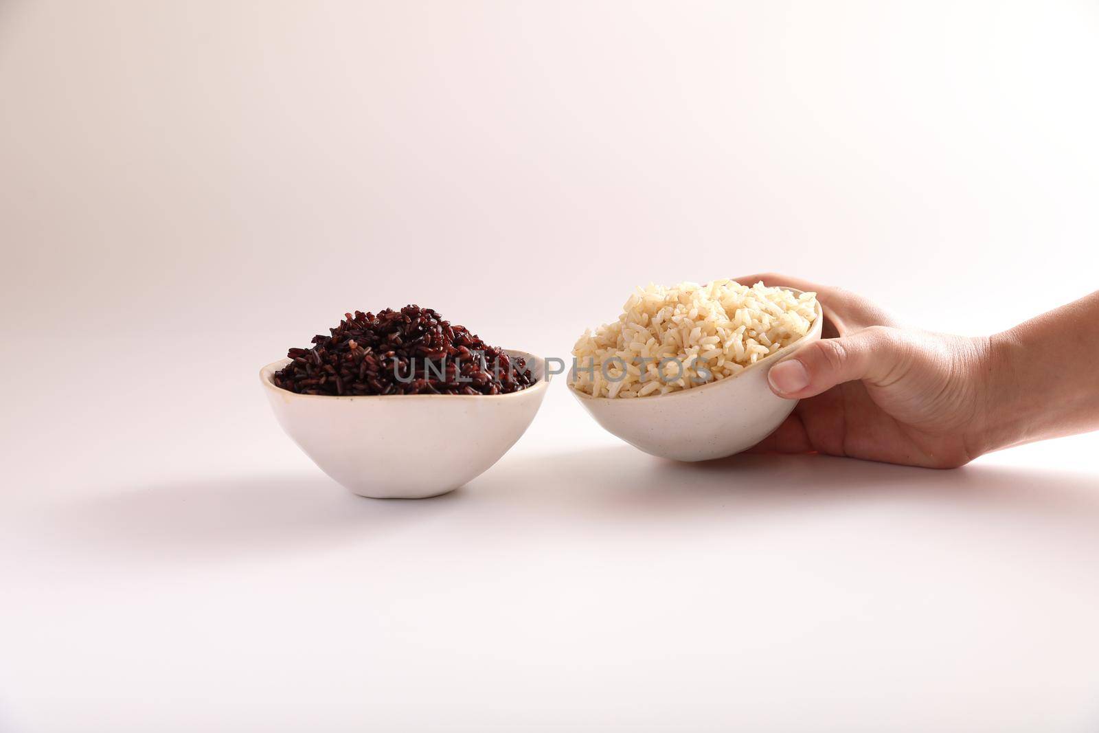 Organic boiled brown rice on bowl isolated in white background by piyato