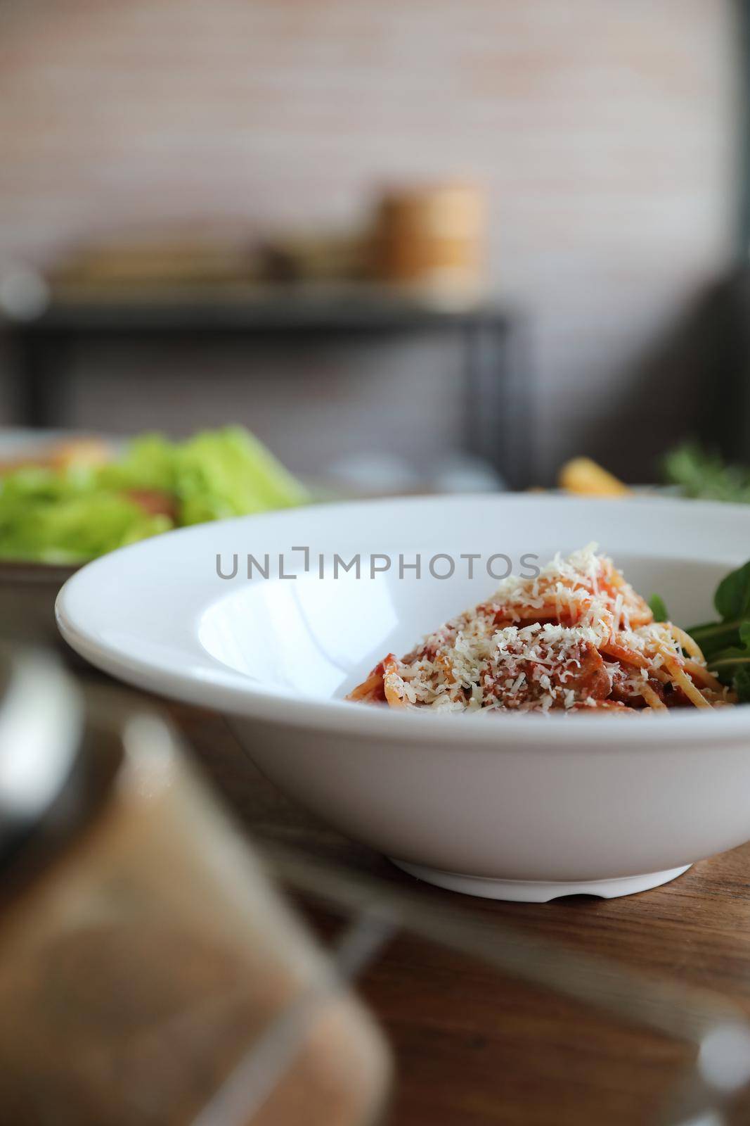 spaghetti Bolognese with italian sausage and tomato sauce with parmesan cheese and basil 