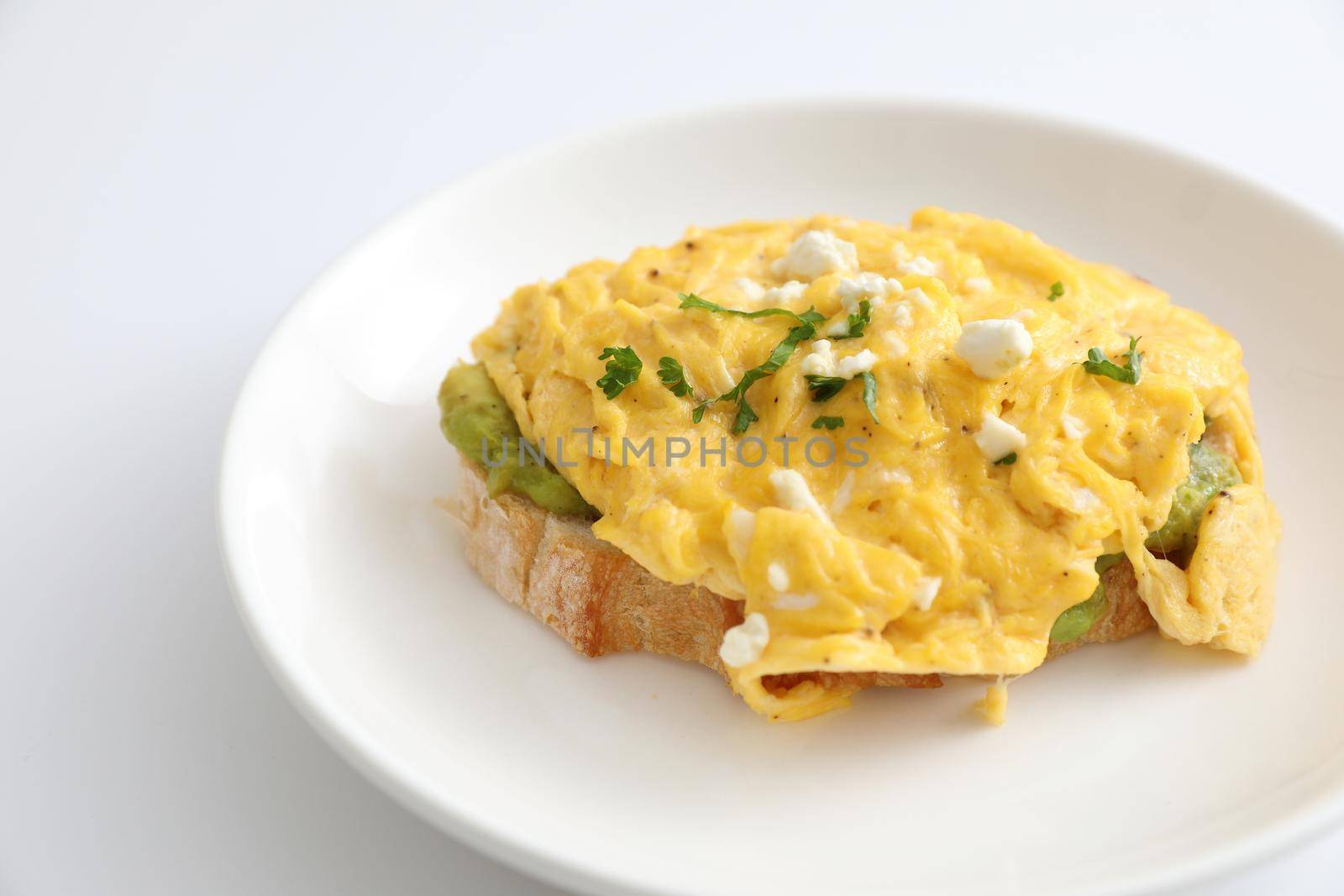Avocado and scrambled eggs toast by piyato