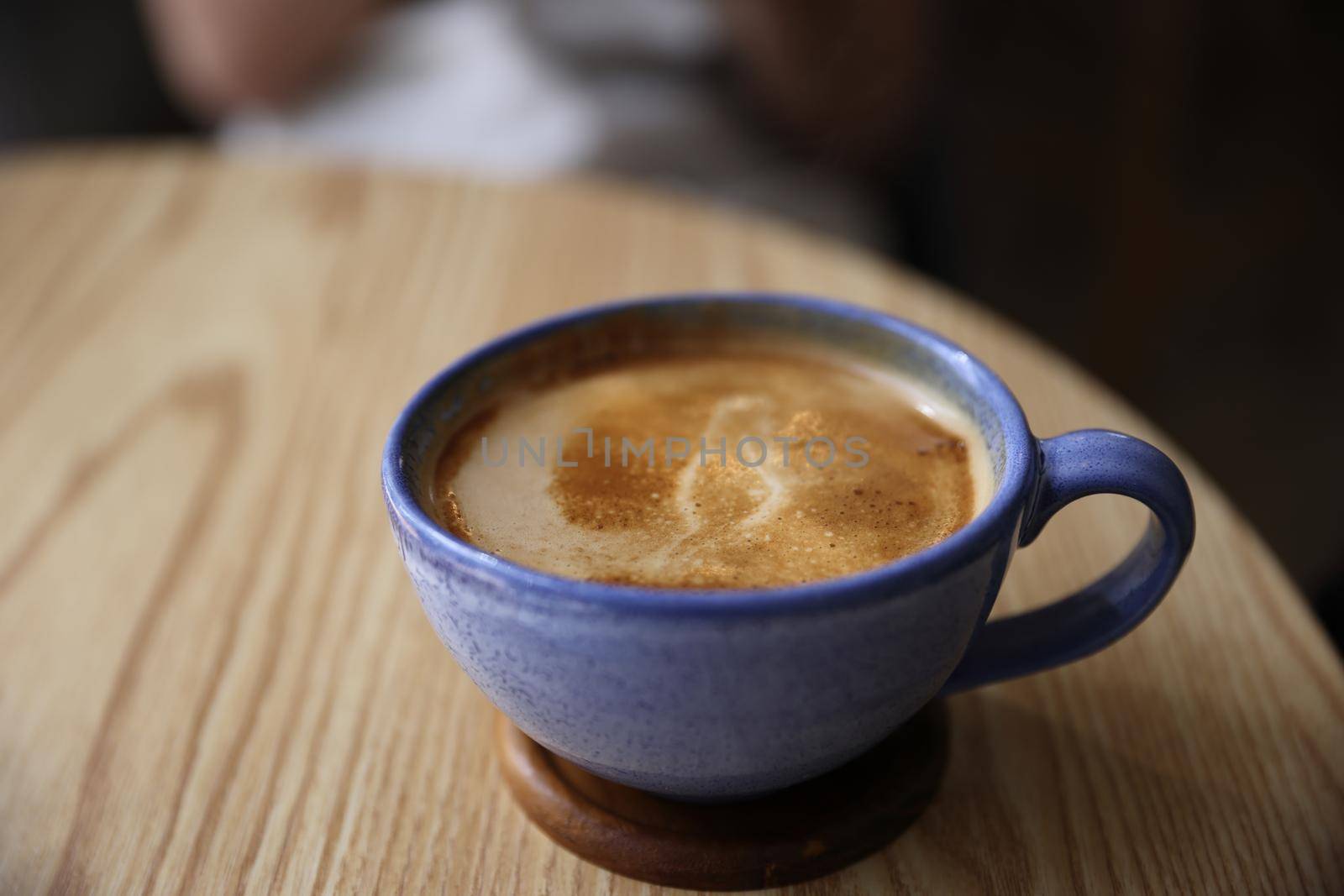 Cappuccino coffee on wood and blur sitting female background