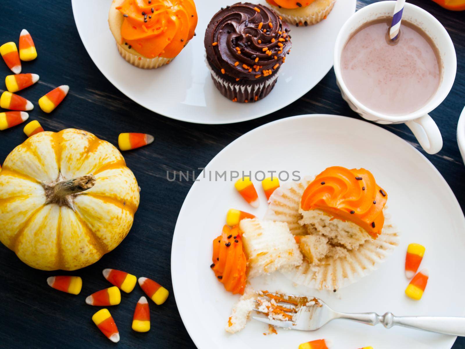 Eating Halloween cupcakes with orange and black icing.