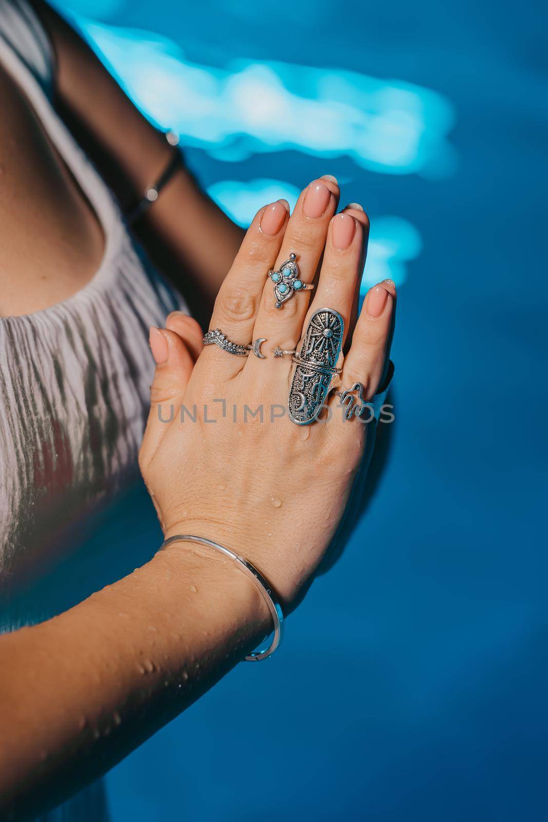 Woman holding namaste in clean water. Palms with gypsy boho rings. Meditation, praying, gratitude, purity background. . High quality photo