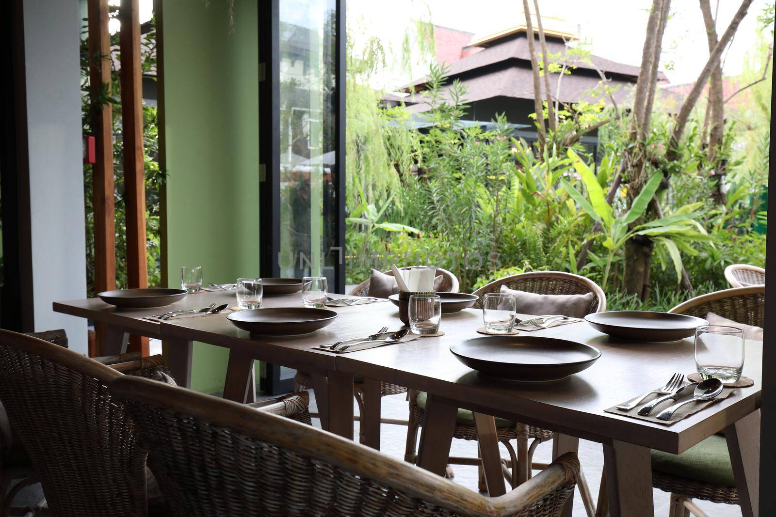 Table set with silverware dish and glass in restaurant by piyato