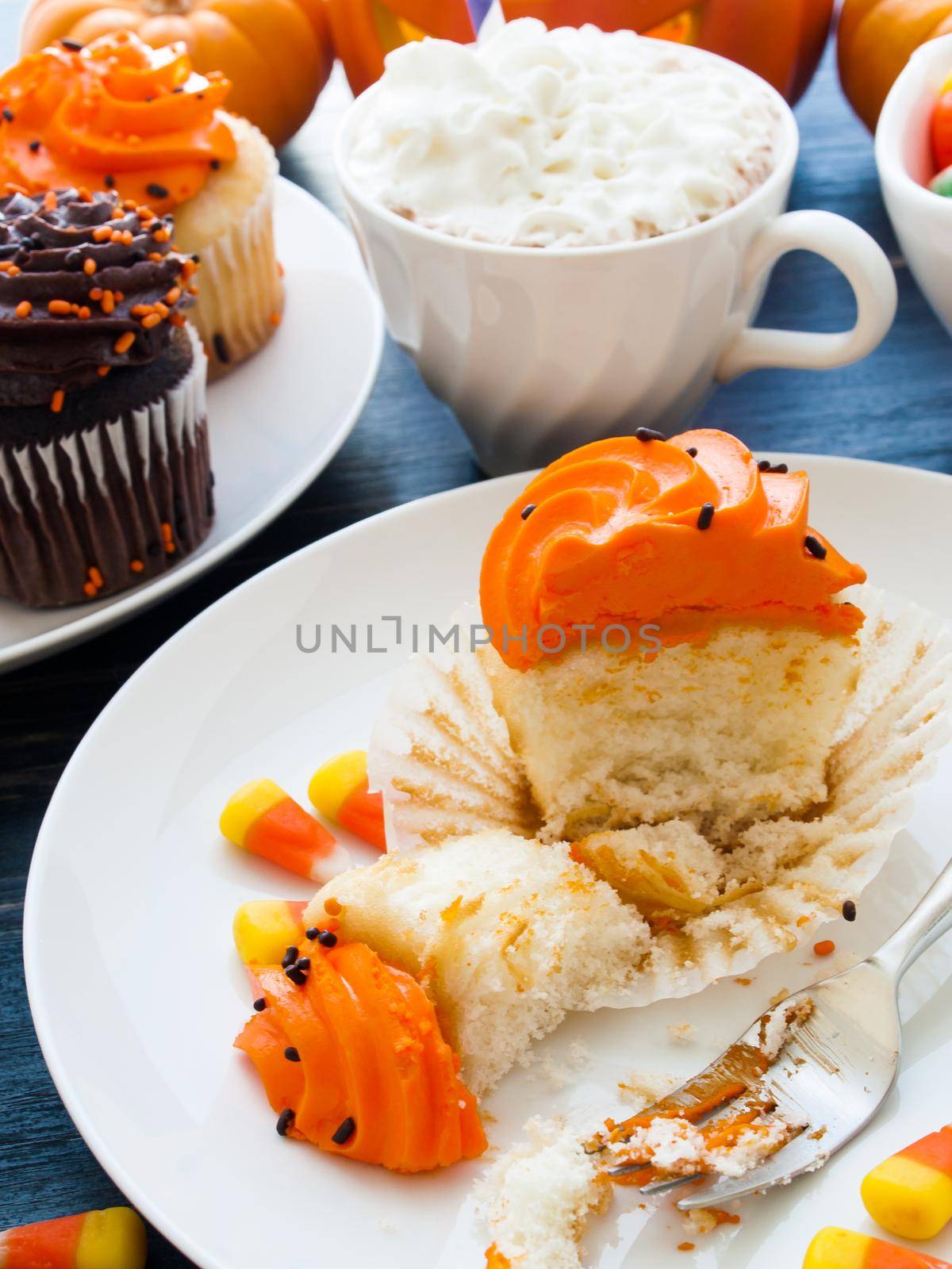 Eating Halloween cupcakes with orange and black icing.