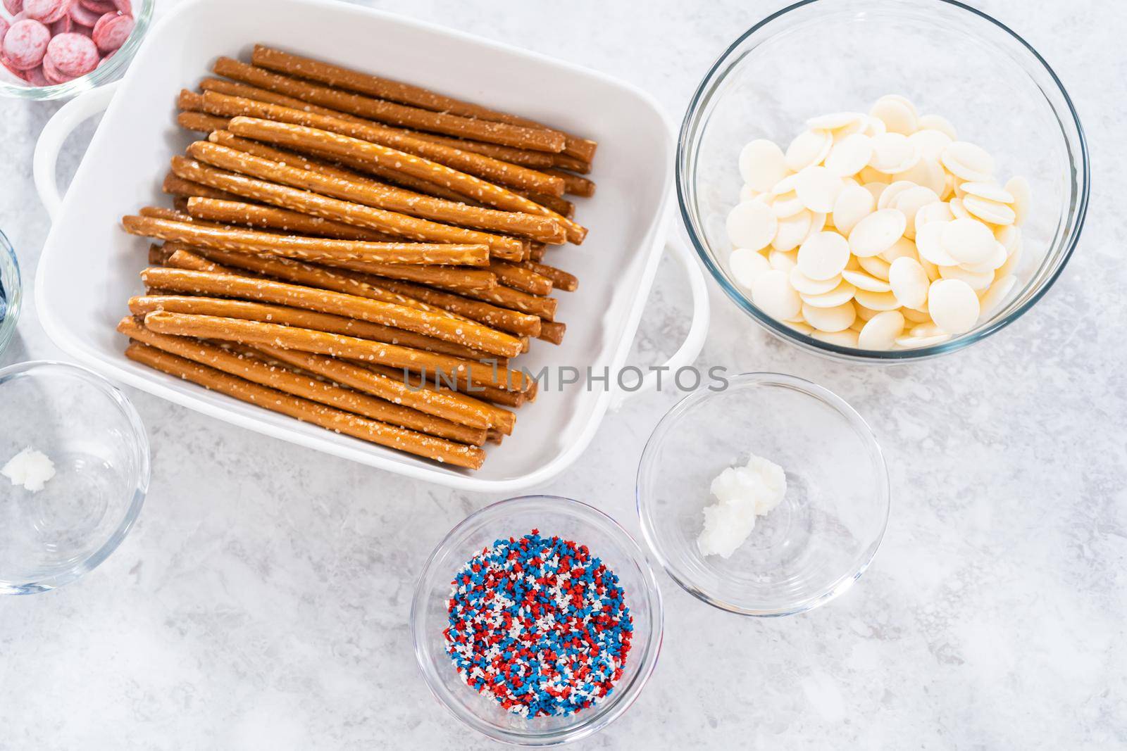 Ingredients in glass mixing bowls to prepare chocolate dipped pretzel rods for the July 4th celebration.