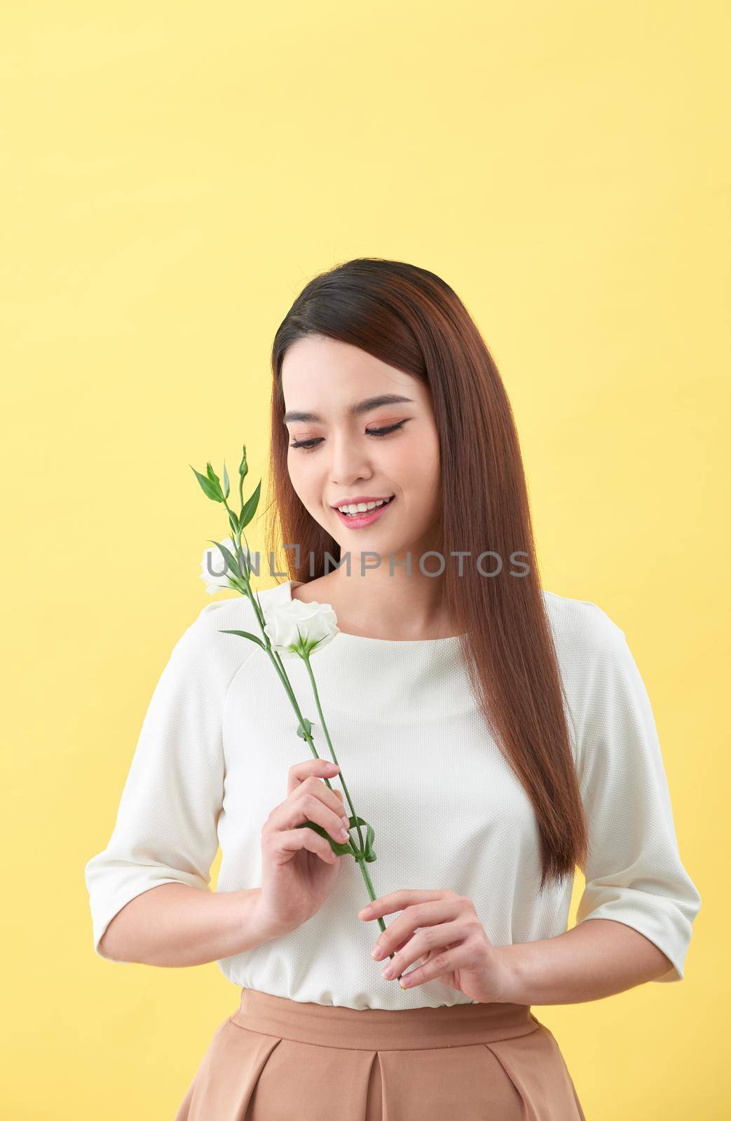 Close up portrait of an attractive young woman holding flower by makidotvn