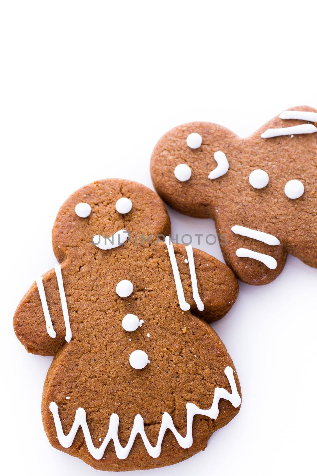Homemade gingerbread cookies decorated with white icing on white background.