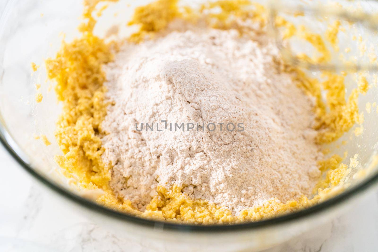 Mixing ingredients with a hand mixer to bake eggnog cookies with a chocolate gingerbread man.