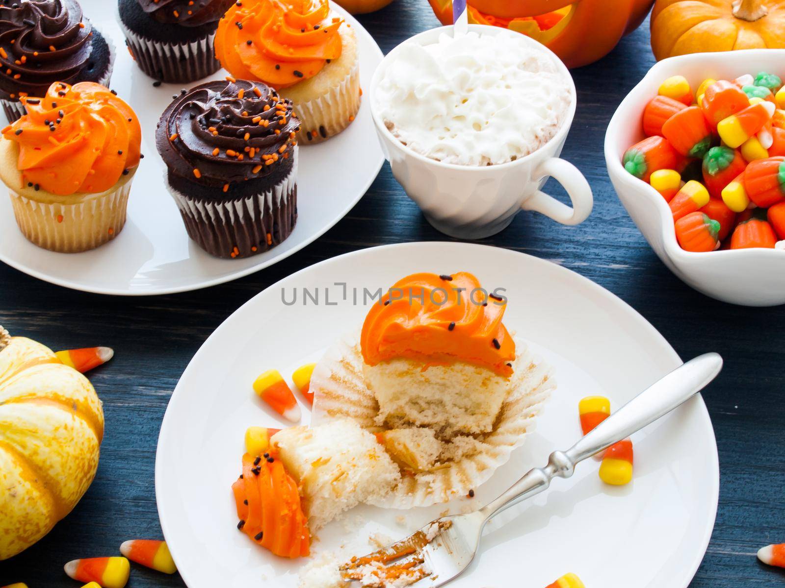 Eating Halloween cupcakes with orange and black icing.